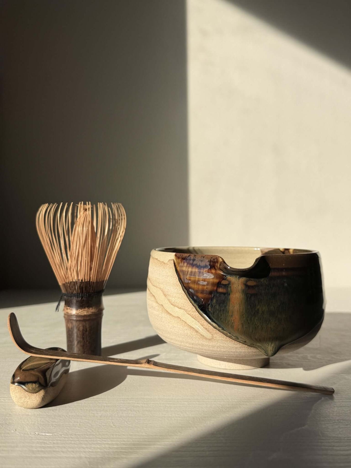 Matcha Bowl with Spout – Inyo #03 handmade ceramic with whisk and spoon, featuring dark glossy tenmoku and clear glazes on stoneware.