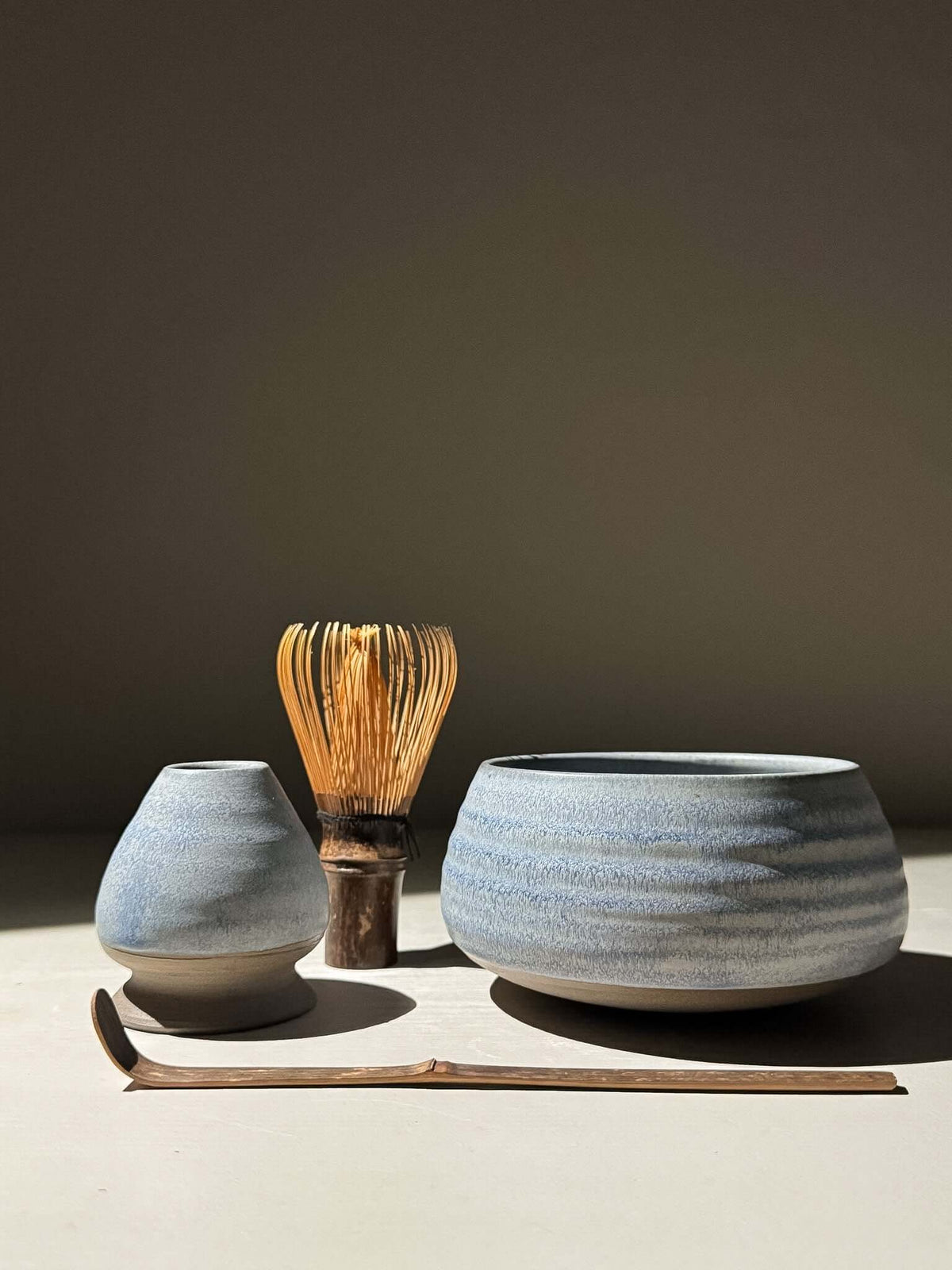 Matcha Whisk Holder - Mizu with bamboo whisk, blue glaze, and stoneware bowl on display