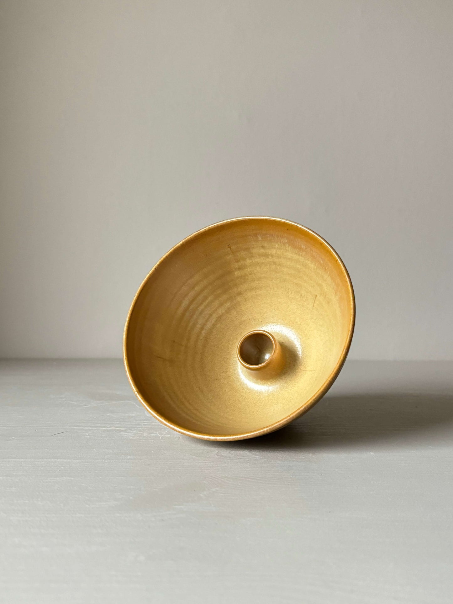 Handmade golden yellow stoneware candlestick holder, 9cm tall and 15cm wide, showcasing a unique wheel-thrown design for home decor.