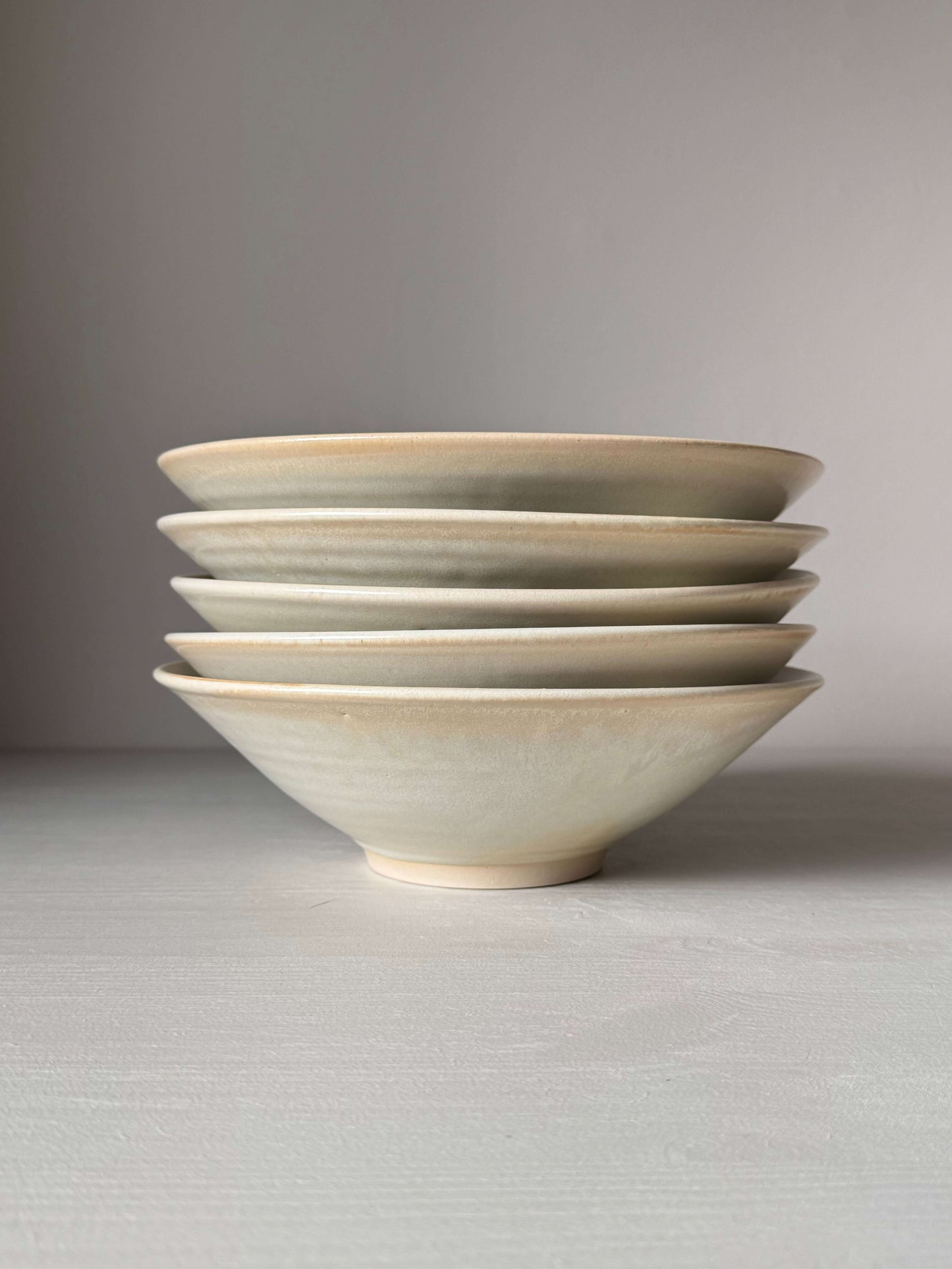Stack of handmade shallow dishes with Moonstone glaze, wheel-thrown stoneware, 6cm by 22cm, food-safe, slight variations expected.