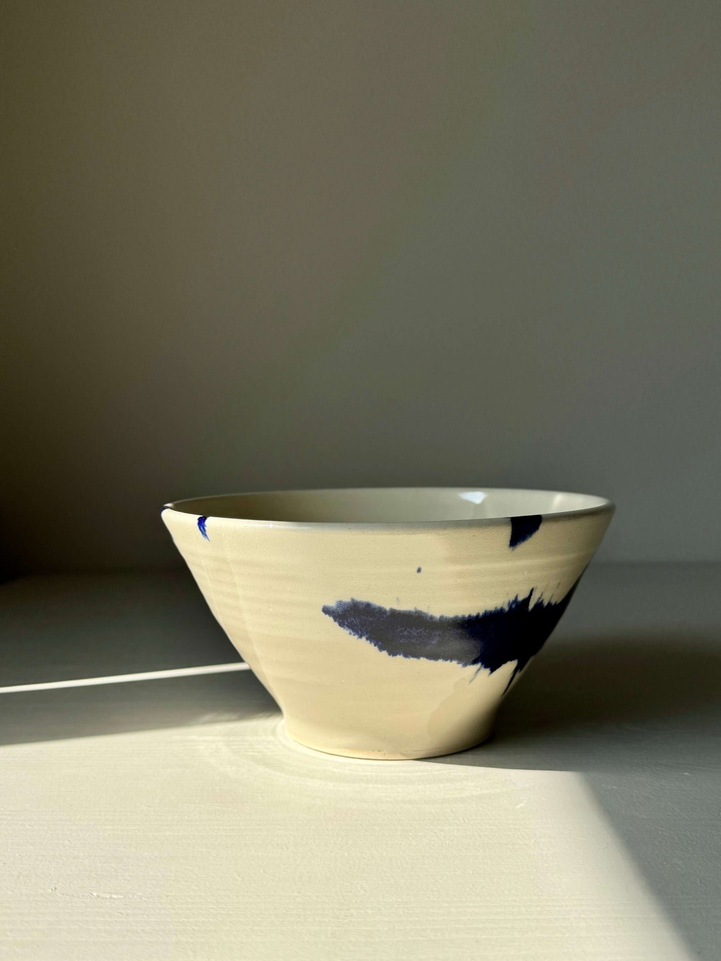 Handmade ceramic breakfast bowl from the Gosu Series with cobalt blue splashes, perfect for morning meals. Functional and artistic design.