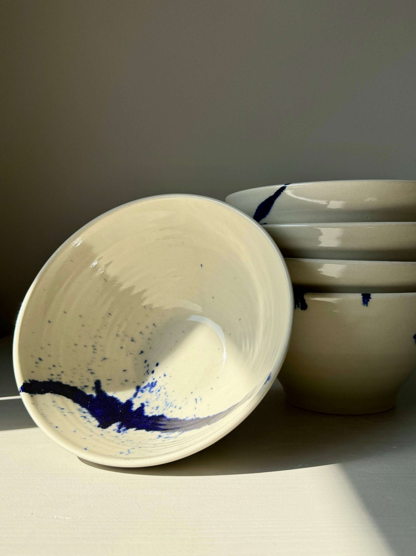 Handmade ceramic breakfast bowls with cobalt blue accents from the Gosu Series, showcasing unique artistry and functionality.