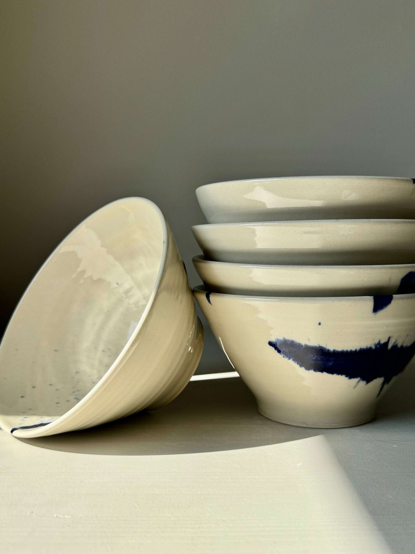 Handmade ceramic breakfast bowls with cobalt blue accents from Gosu Series, showcasing artistic design and functional shape.