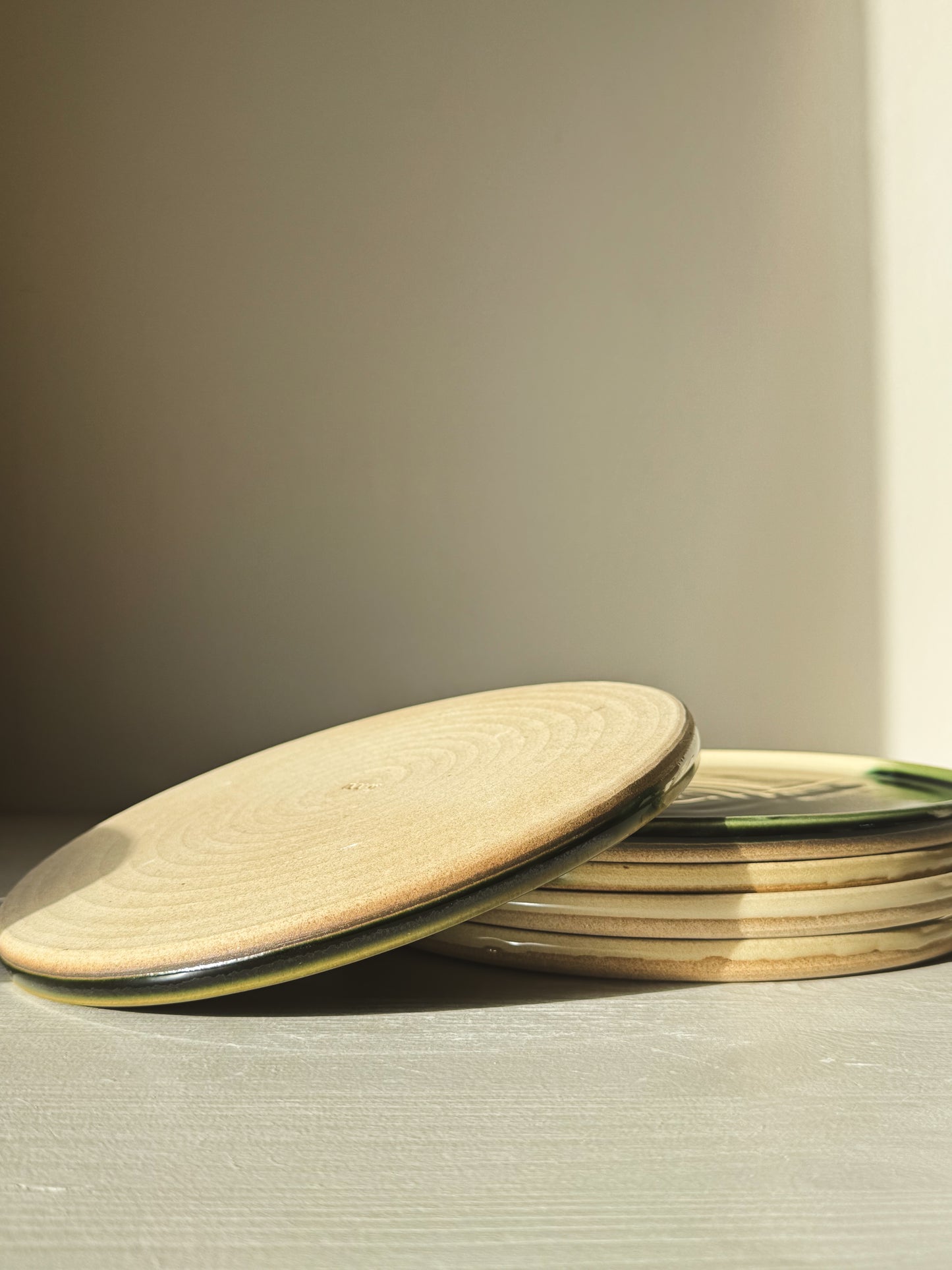 Flat Round Breakfast Plate – Mori series showcasing a stack of plates with natural toffee clay tones and glossy glaze finish.