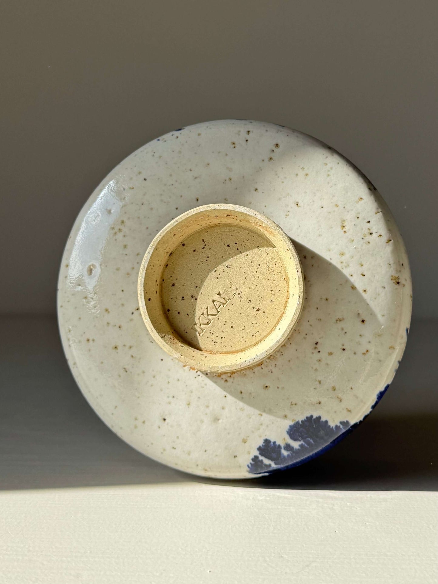 Base of Matcha Bowl – Cobalt Blue & Glossy White #02, handmade ceramic, showing signature and subtle splash of cobalt glaze.