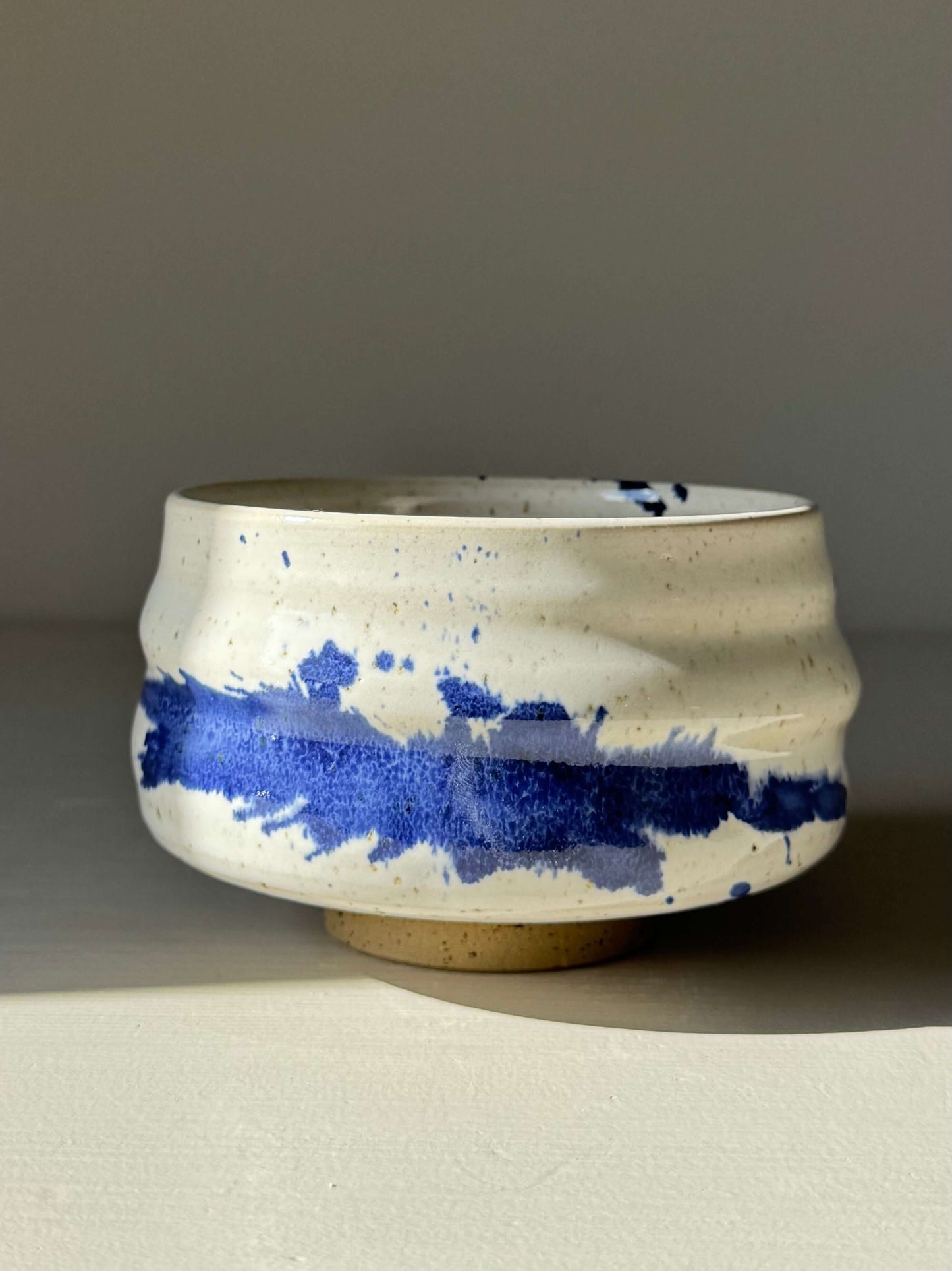 Matcha Bowl – Cobalt Blue & Glossy White #01, handmade ceramic with flowing ridges and vibrant splash pattern in cobalt and white glaze.