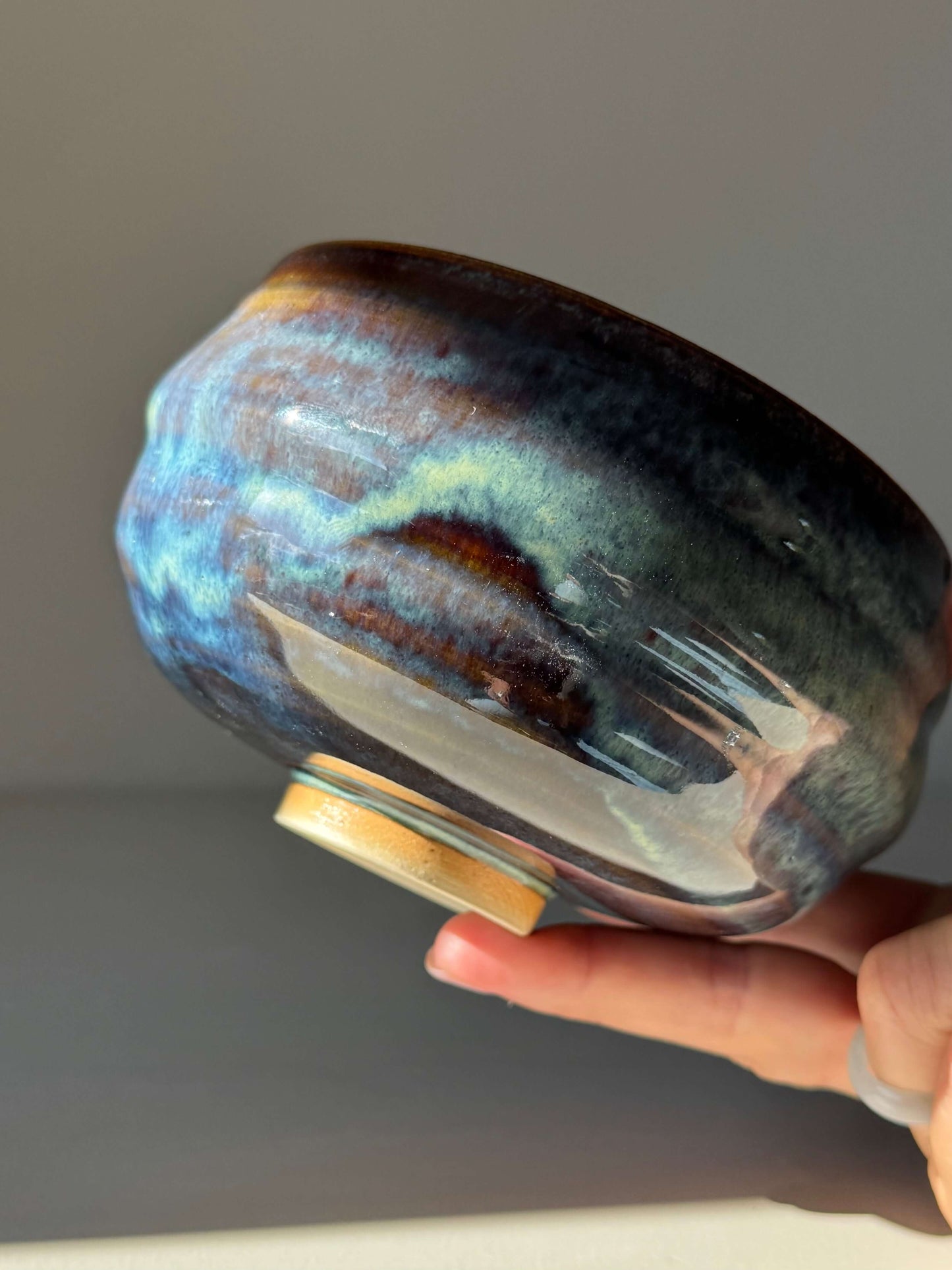 Handmade ceramic Matcha Bowl - Glossy Blue #03 with earthy tones and flowing blue glaze, showcasing unique unpredictable design.
