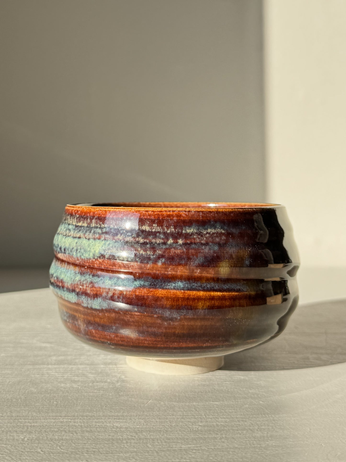 Matcha Bowl - Glossy Blue #03 with earthy tones and flowing blue glaze on a textured, curved design.