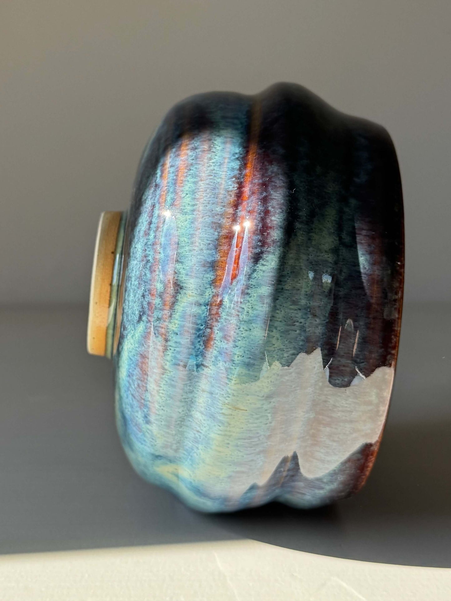 Matcha Bowl - Glossy Blue #02, handmade ceramic with deep earthy tones and flowing blue patterns, side view displaying unique textures.