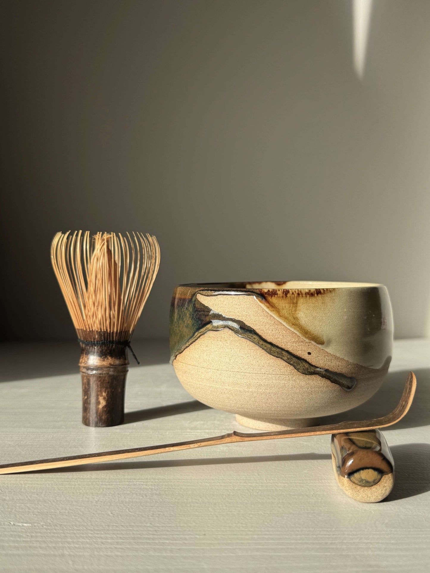 Handmade ceramic Matcha Bowl – Inyo #04 with bamboo whisk and scoop on a light surface.