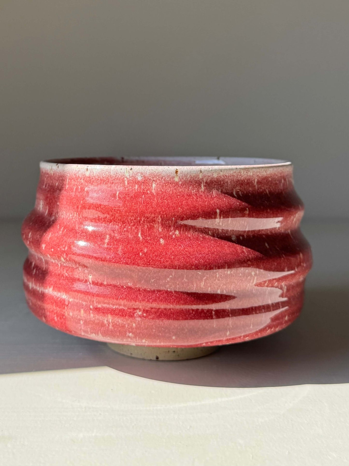 Handmade ceramic Matcha Bowl - Ume Series #08 in red with flowing ridges and a wide foot, inspired by Japanese Ume blossom.