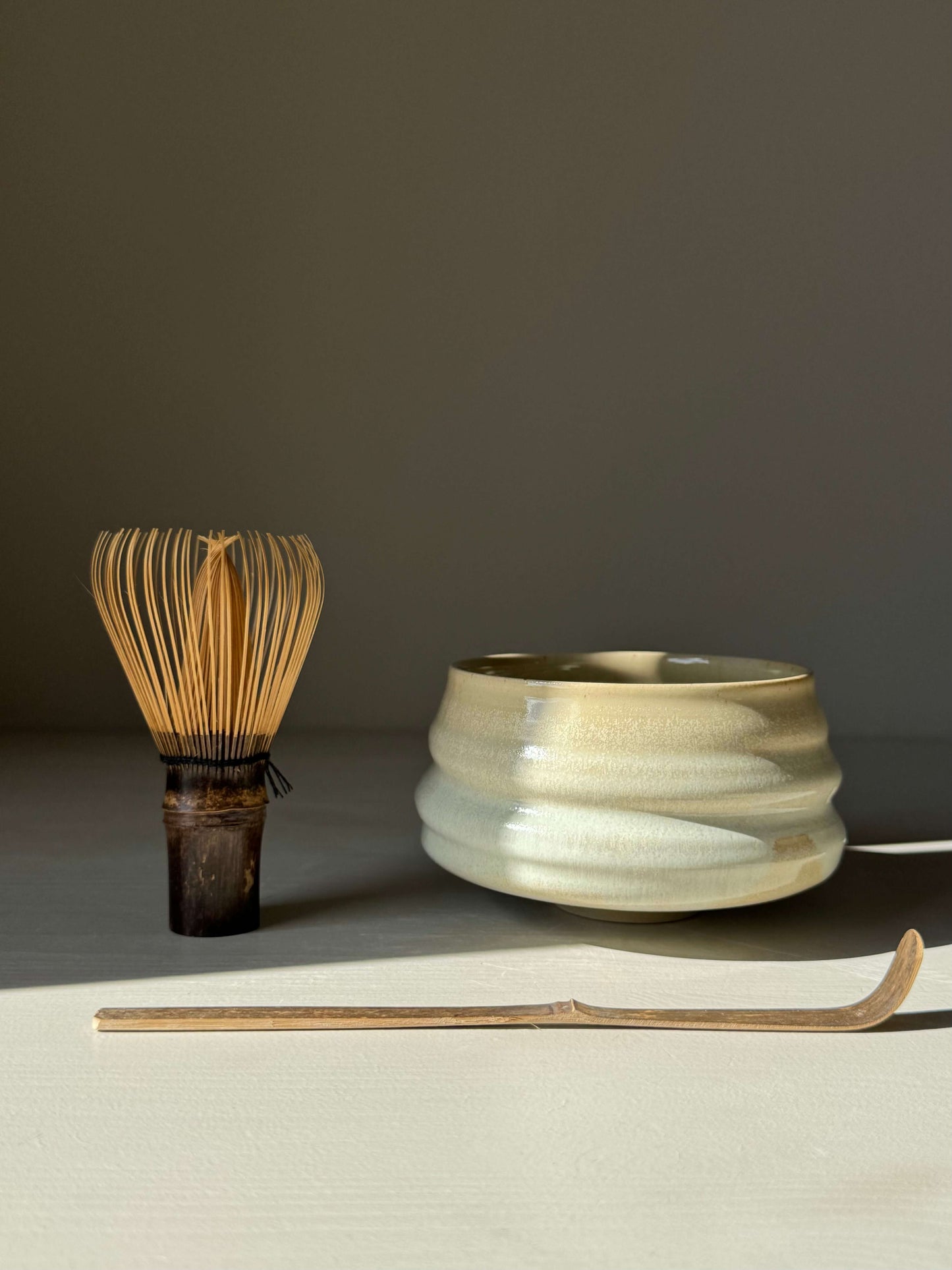 Matcha Bowl – Moonstone Glaze with whisk and scoop, handmade ceramic with ridged design, captures light beautifully.