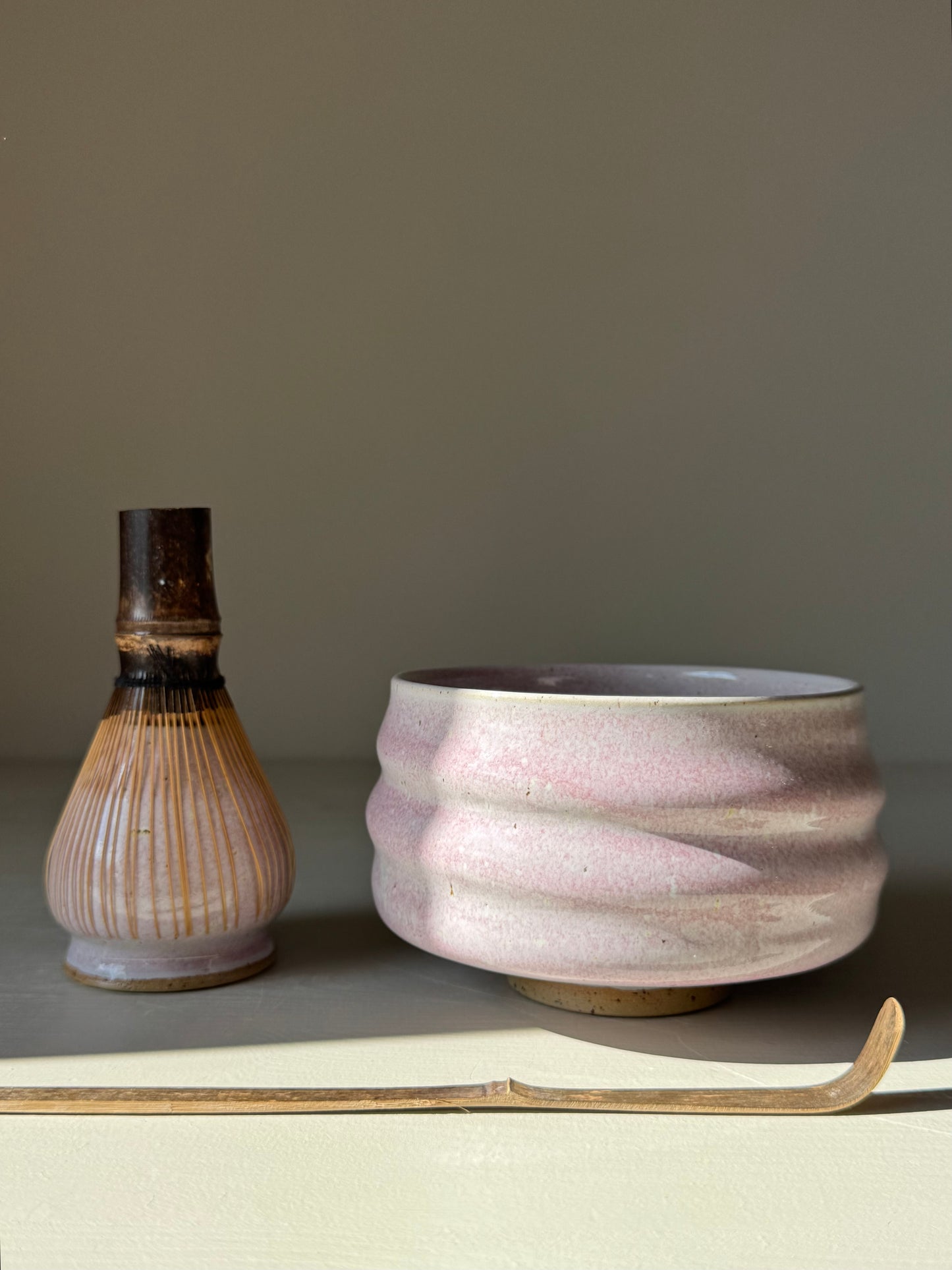 Pale pink handmade ceramic Matcha Bowl with sculpted ridges, capturing light beautifully. Perfect blend of simplicity and character.