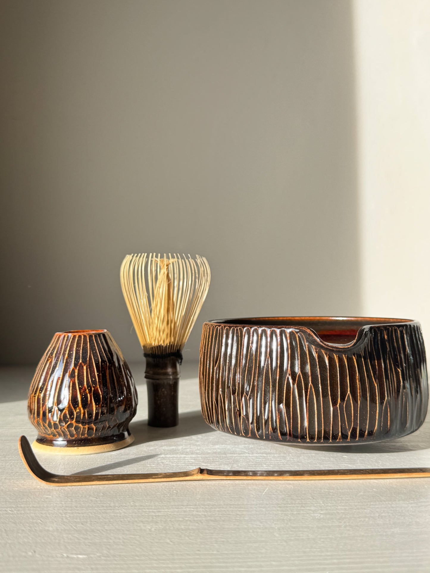 Matcha Bowl Spout – Kinsei #02 with hand-carved design and rich glaze, accompanied by traditional matcha whisk and accessory.