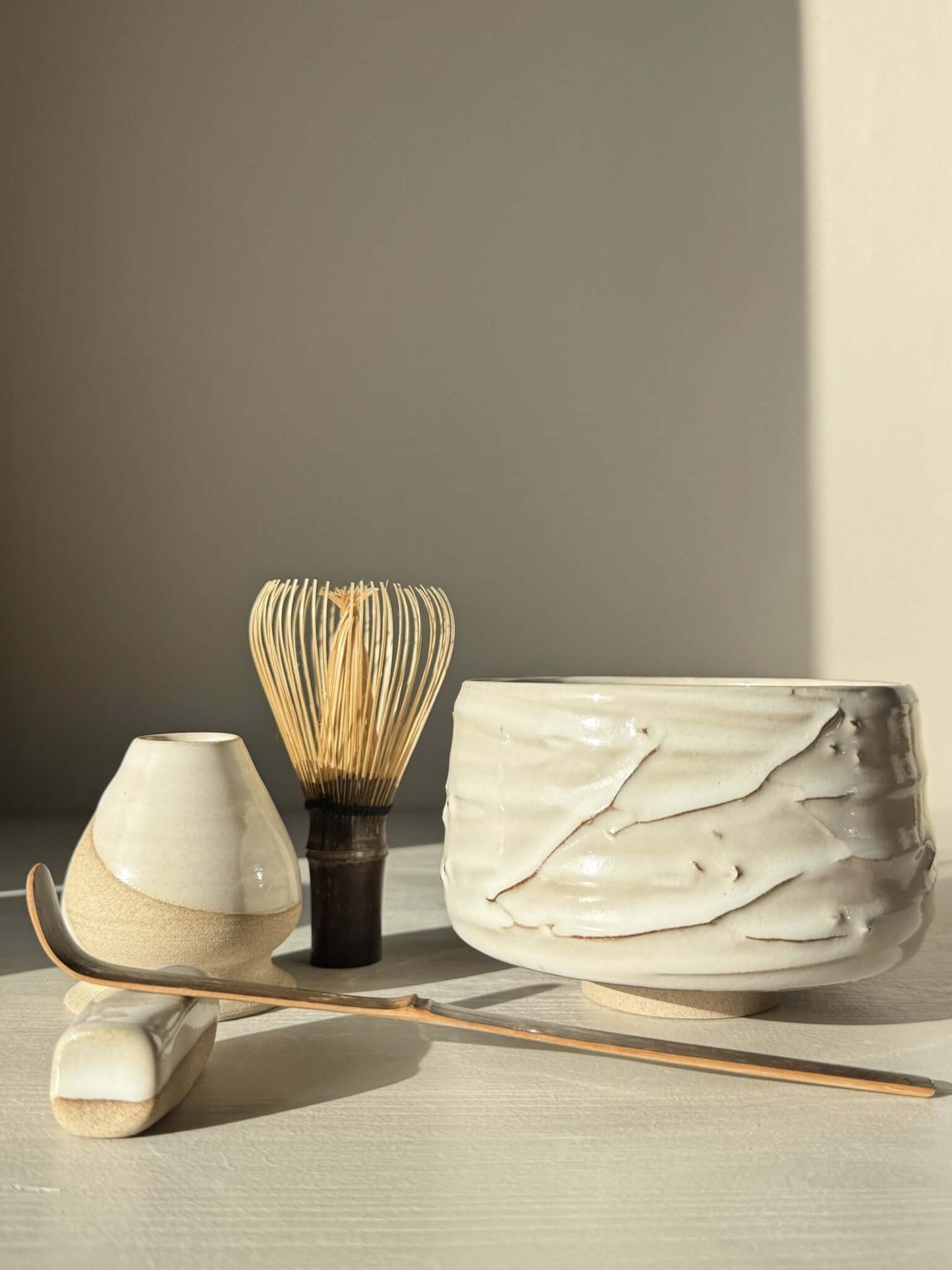 Matcha Bowl – Yuki Branches #01 with whisk, scoop, and water vessel in soft ivory glaze, showcasing delicate slip lines and tactile finish.
