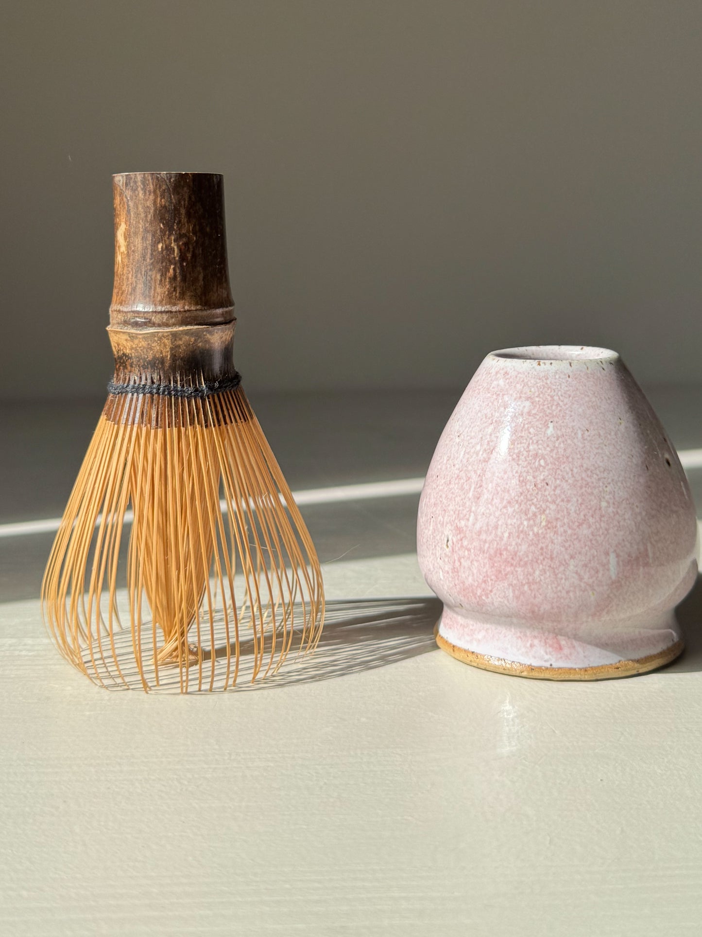 Matcha Whisk Holder - Pale Pink with handmade ceramic design and bamboo whisk, adding elegance to tea setups with its soft, unique glaze.