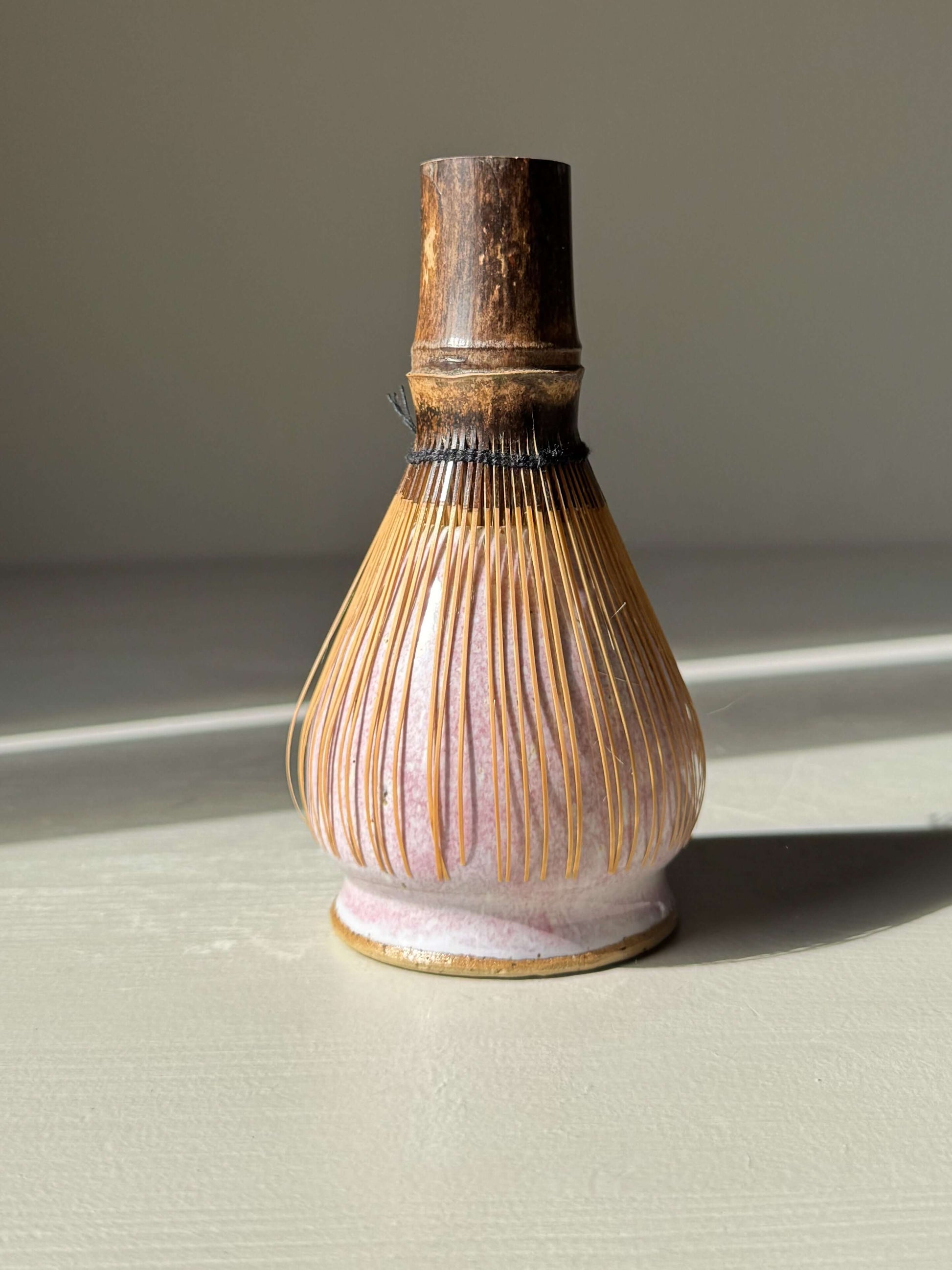 Matcha Whisk Holder - Pale Pink handmade ceramic in sunlight, highlighting its unique color and texture.