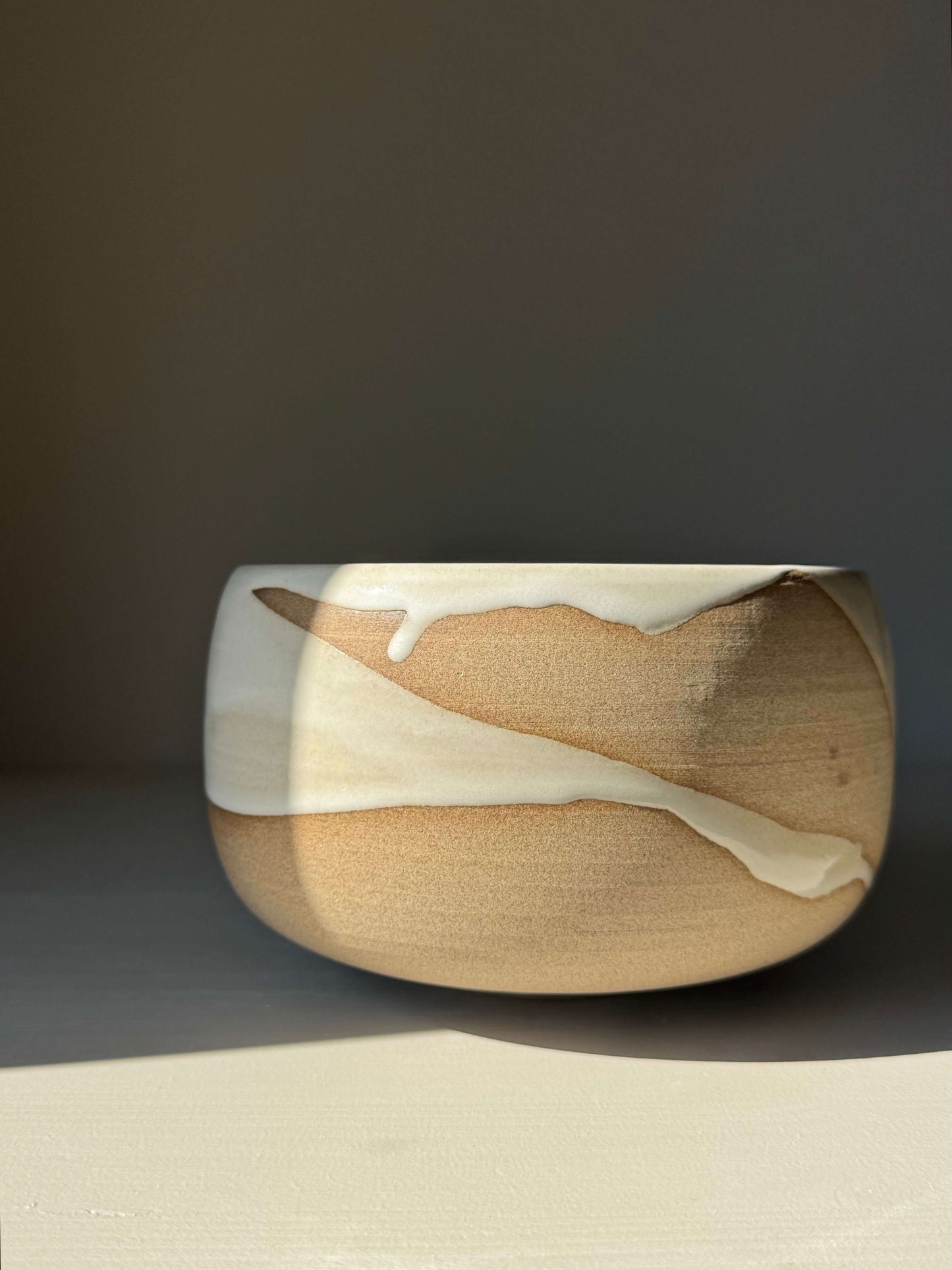 Medium Bowl - Yuki #01, handmade ceramic with glossy white glaze over toffee clay, showcasing elegant curves and natural texture.