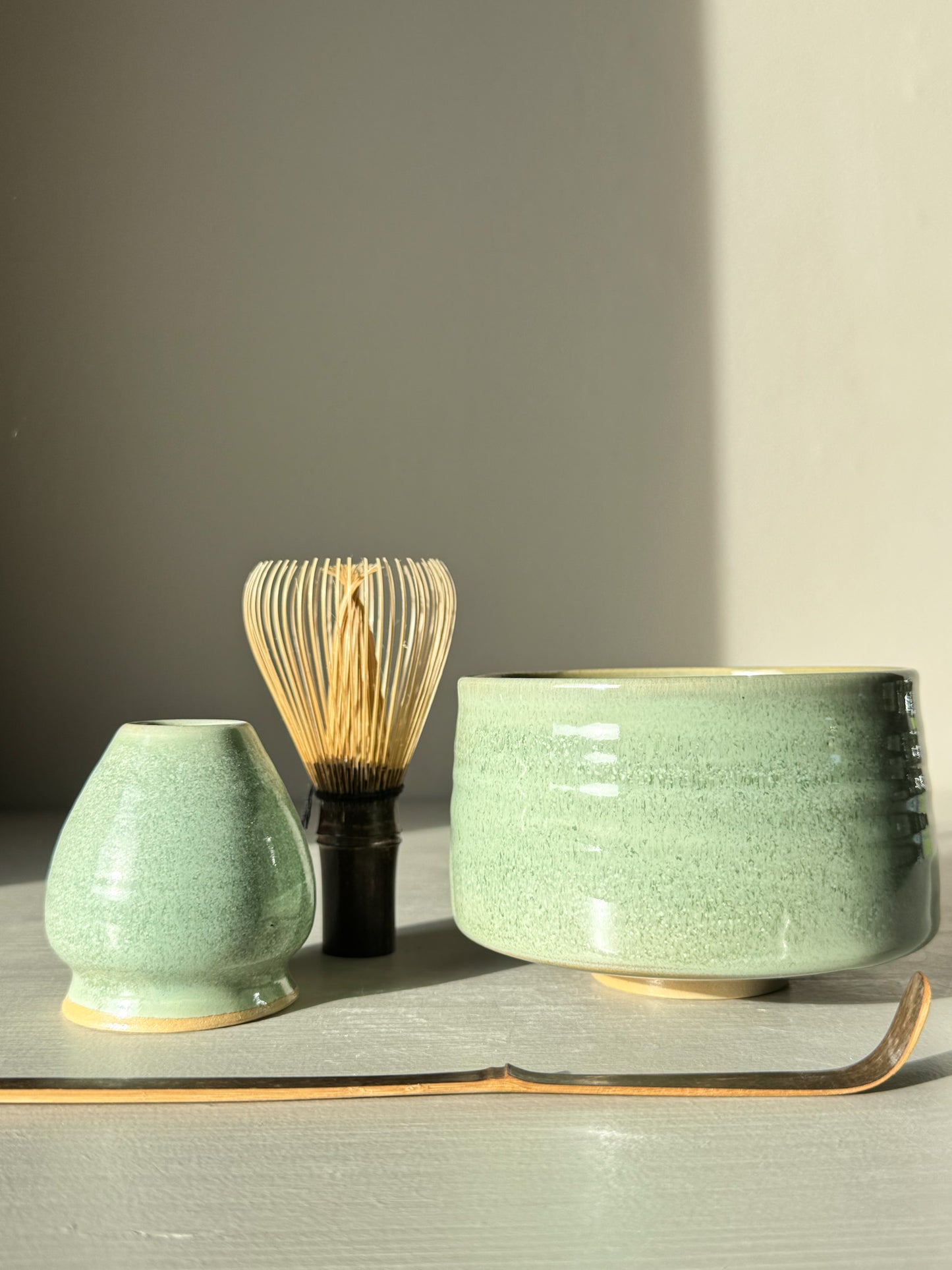 Matcha Bowl – Sage Glaze #01 with chasen and tea accessories, featuring a glossy sage-green glaze perfect for whisking smooth matcha.