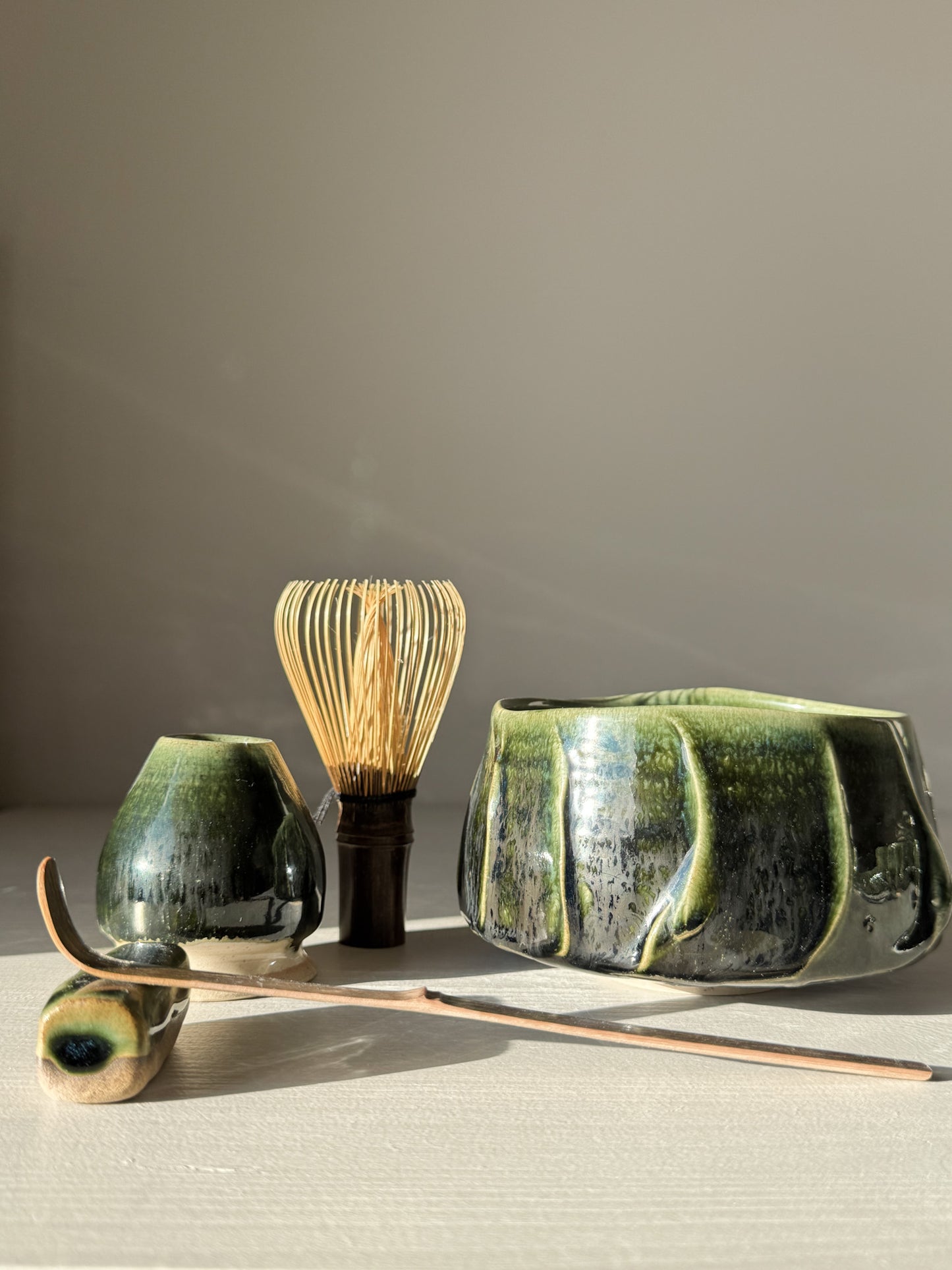 Textured Matcha Bowl - Hinoki #03 with green glaze and unique finish, showcasing the beauty of Japanese tea culture in a peaceful setting.