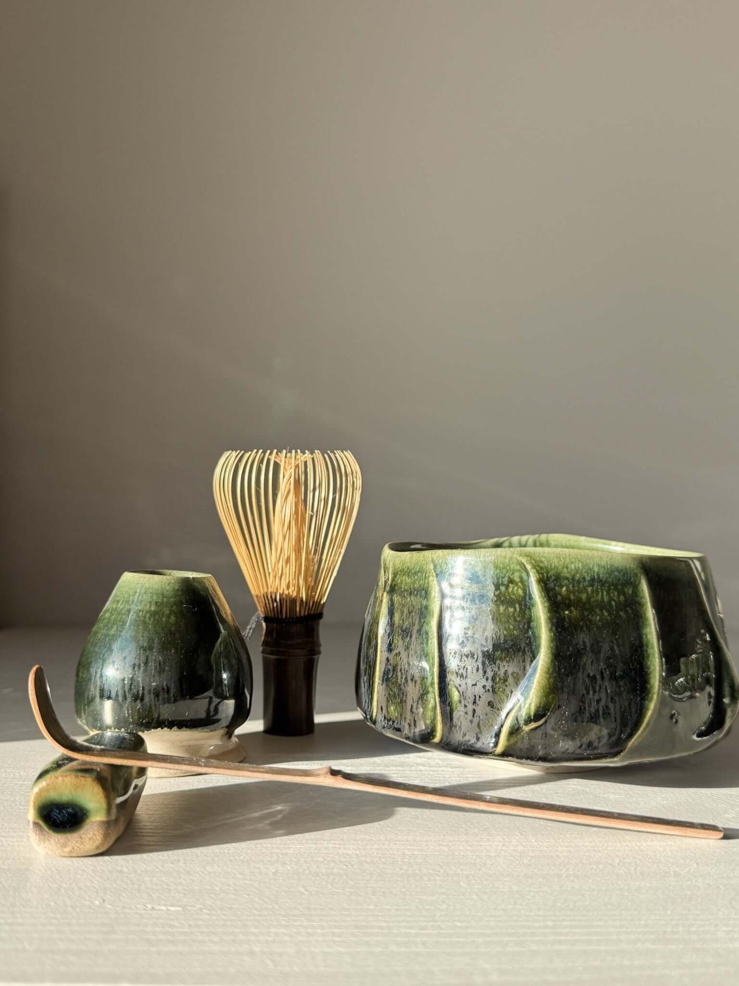 Textured Matcha Bowl - Hinoki #03 with green glaze and unique finish, showcasing the beauty of Japanese tea culture in a peaceful setting.