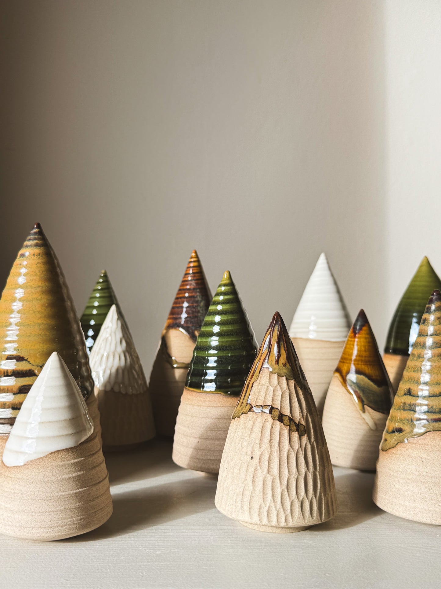 A collection of handcrafted Textured Ceramic Tree – Yuki #03 with glossy glazes and visible ridges, showcasing unique artisanal craftsmanship.