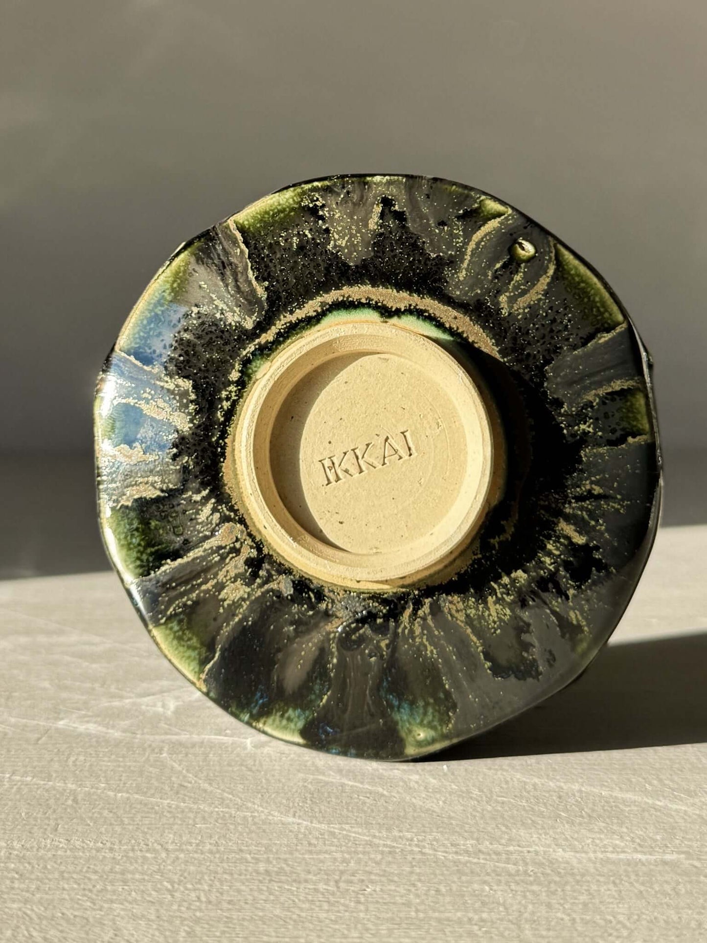 Bottom view of Yunomi Cup - Hinoki #04 with deep green glaze and unique hand-applied slip decoration.