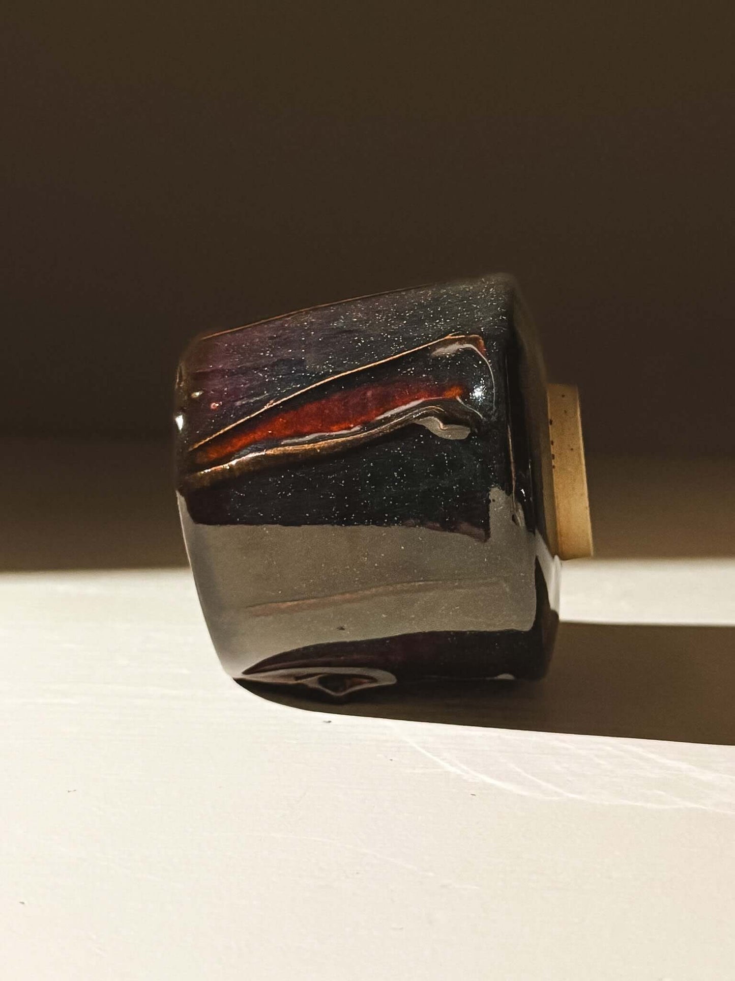 Handmade Yunomi Cup - Kuro with glossy black glaze and deep blue, burgundy, and red highlights.
