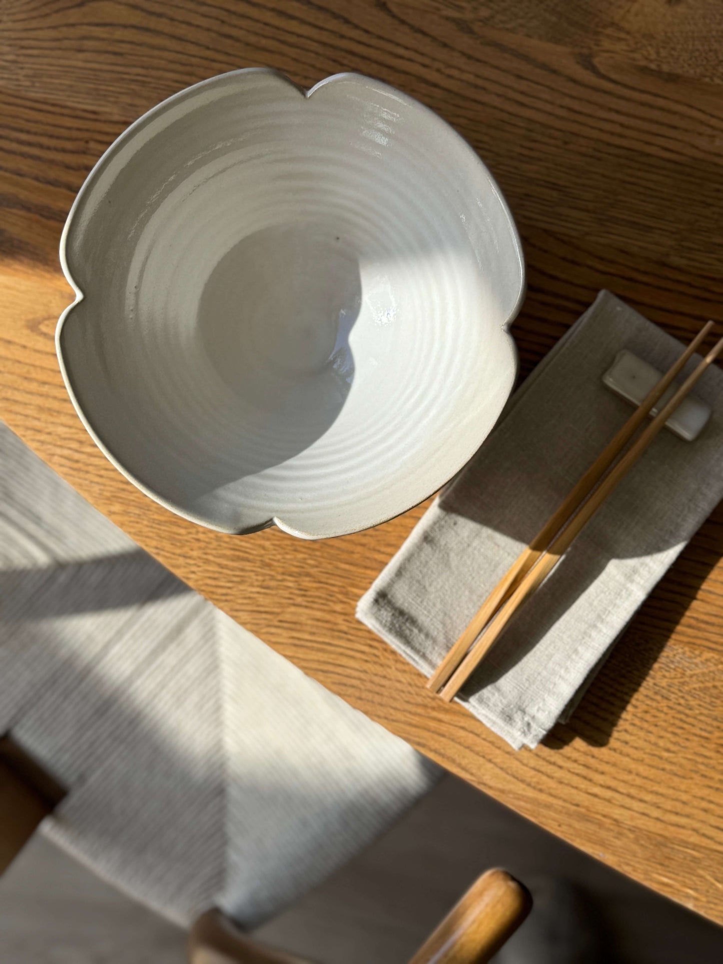 Handmade Flower Ramen Bowl from Yuki Series with scalloped rim on wooden table, ideal for noodle soups and rice dishes.
