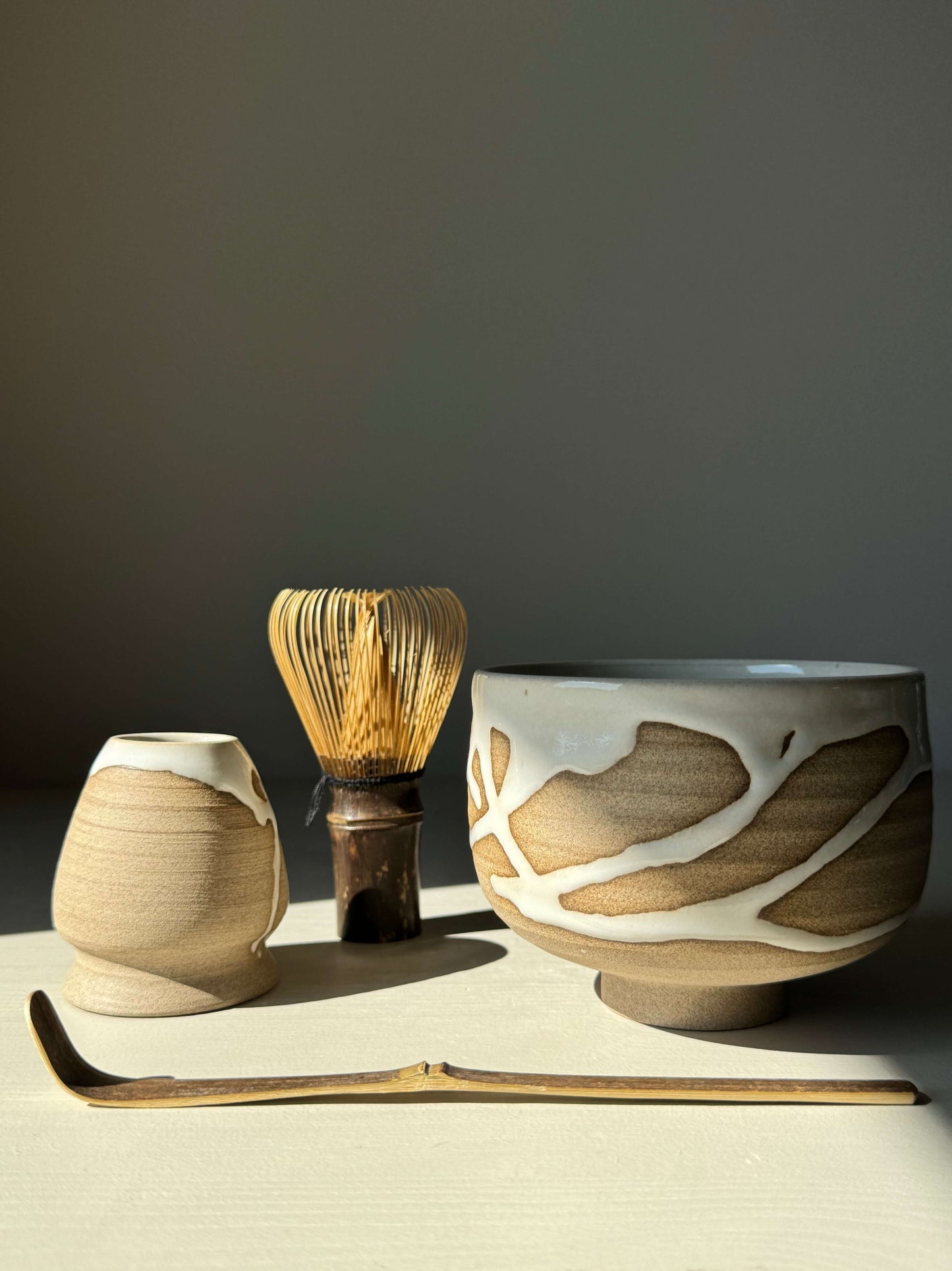 Handmade matcha bowl set with toffee clay and white glaze from the Yuki Series, featuring whisk, scoop, and holder.