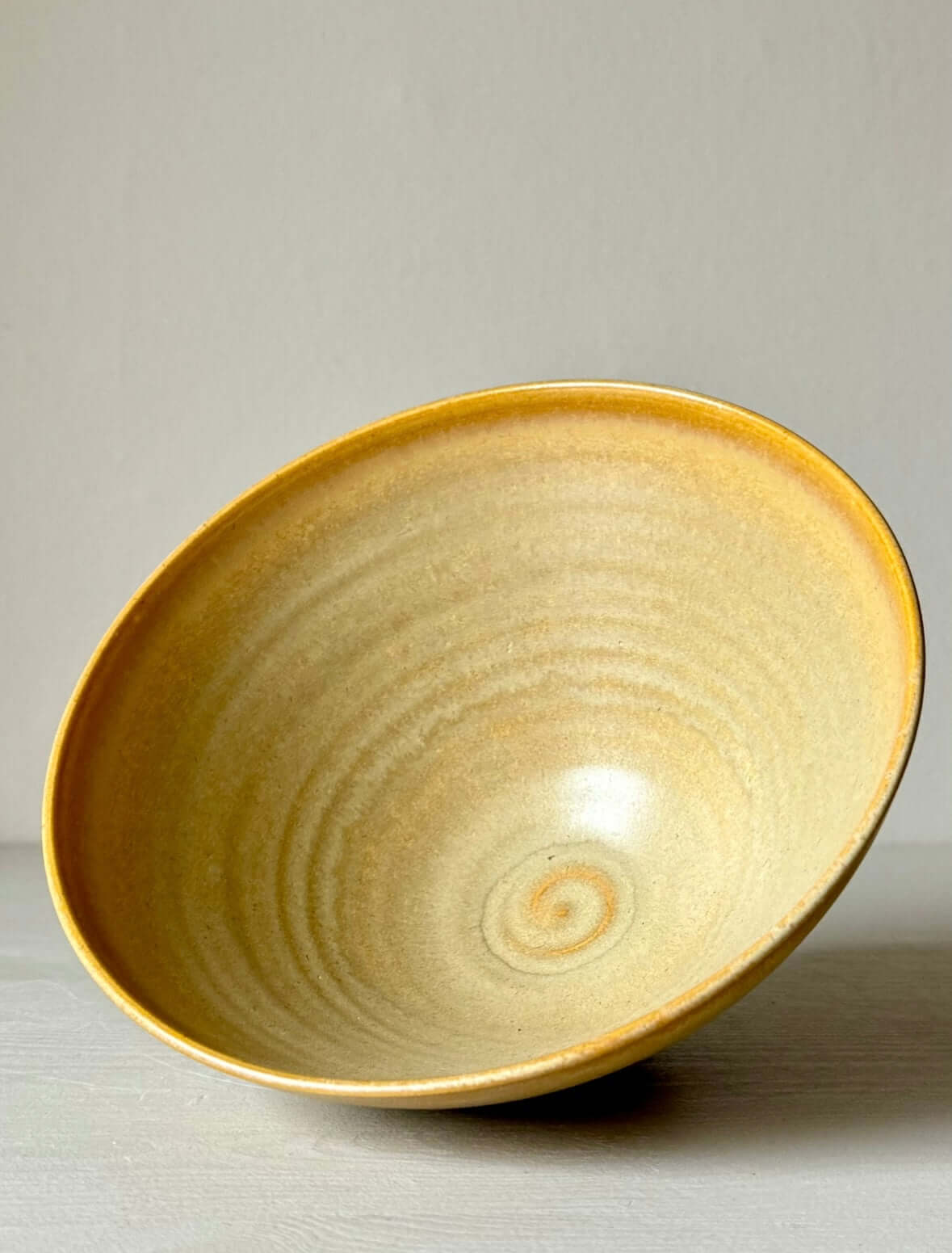 Handmade medium bowl with yellow glaze, crafted from stoneware clay. Perfect for serving soups, desserts; unique artisanal design.