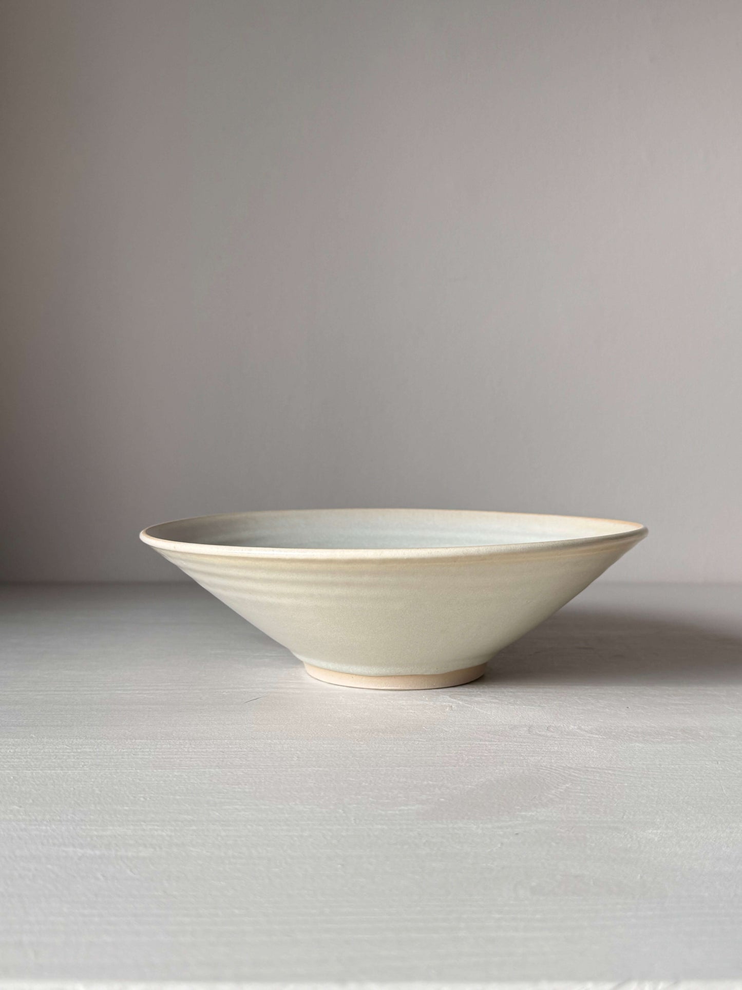 Handmade moonstone glazed shallow dish, wheel-thrown stoneware, 22cm diameter, 6cm height, safe for everyday use, unique ceramic design.