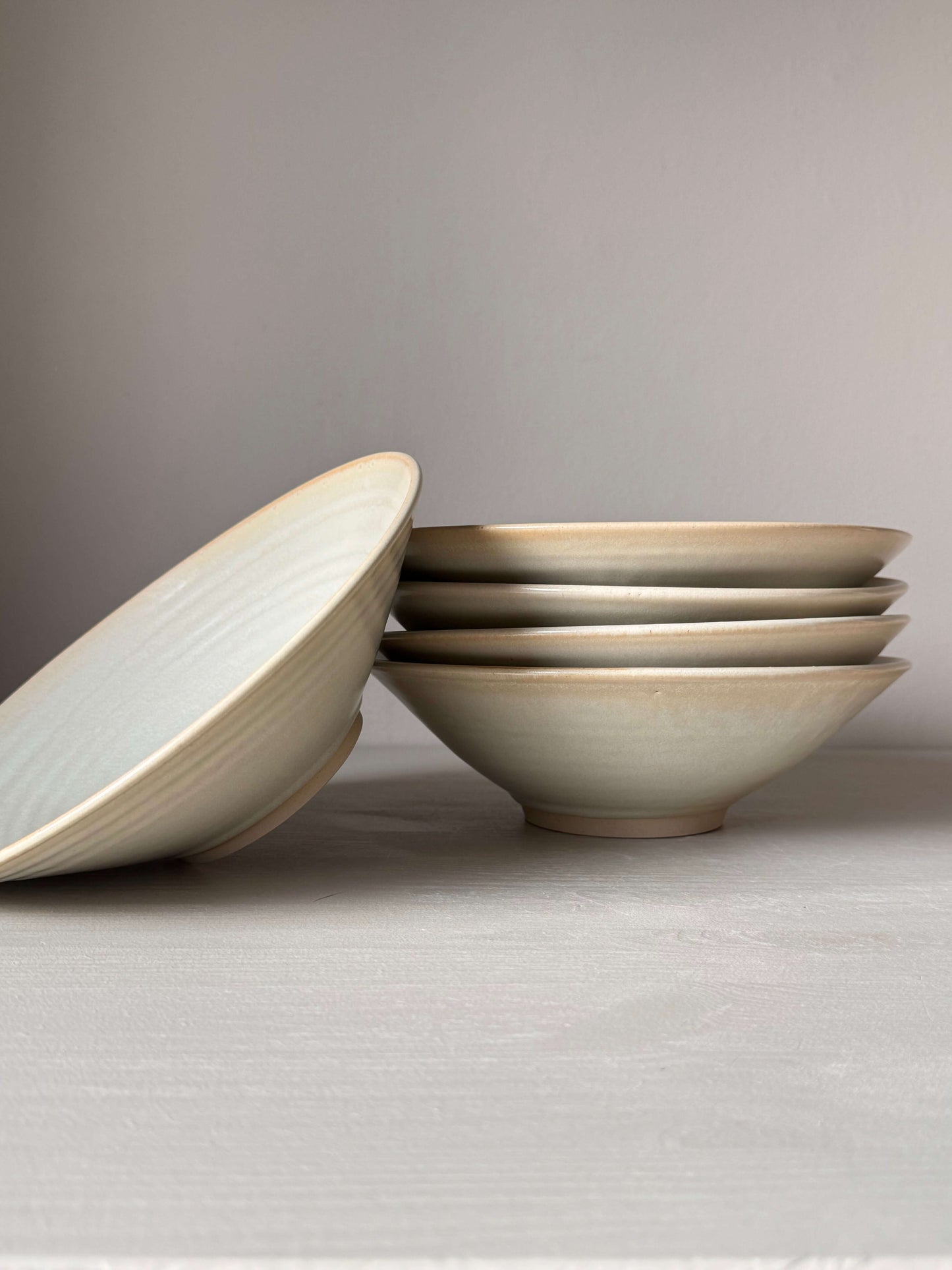 Stack of handmade moonstone-glazed shallow dishes, wheel-thrown stoneware, food-safe, lead-free, 22cm diameter, 6cm height.