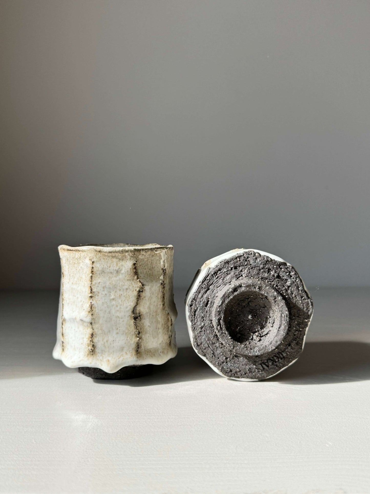 Kurinuki style cups with nuka glaze showcasing hand-carved, earthy design and tactile surface contrast against a smooth texture.