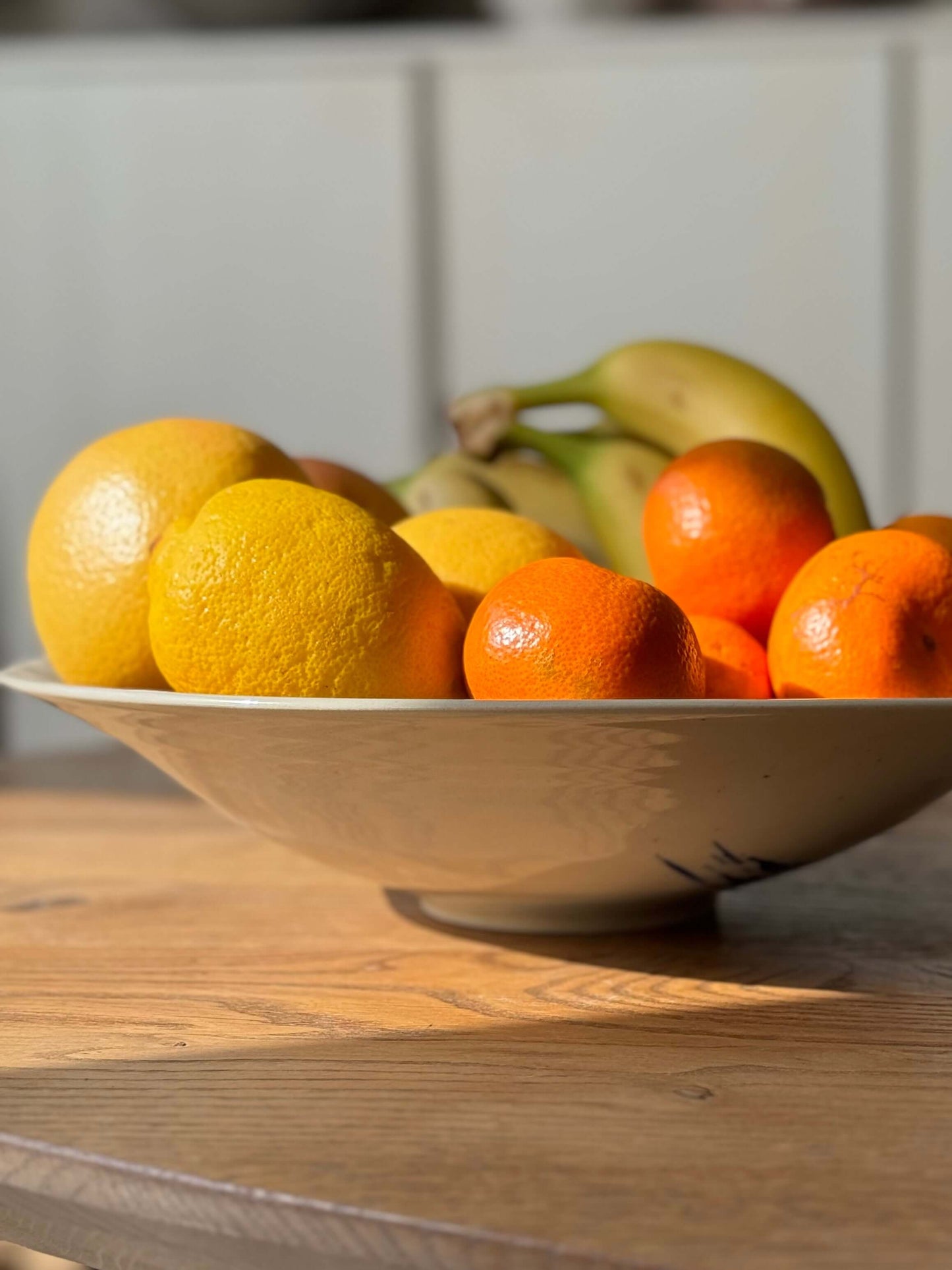 Gosu Series #04 Large Shallow Bowl holding citrus and bananas, durable stoneware 31 cm diameter, adds character to any table.