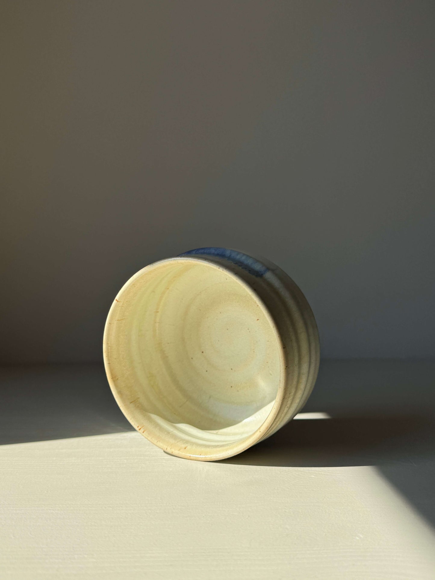 Handcrafted matcha bowl with cobalt blue accents and moonstone glaze, showcasing a unique, rounded design.