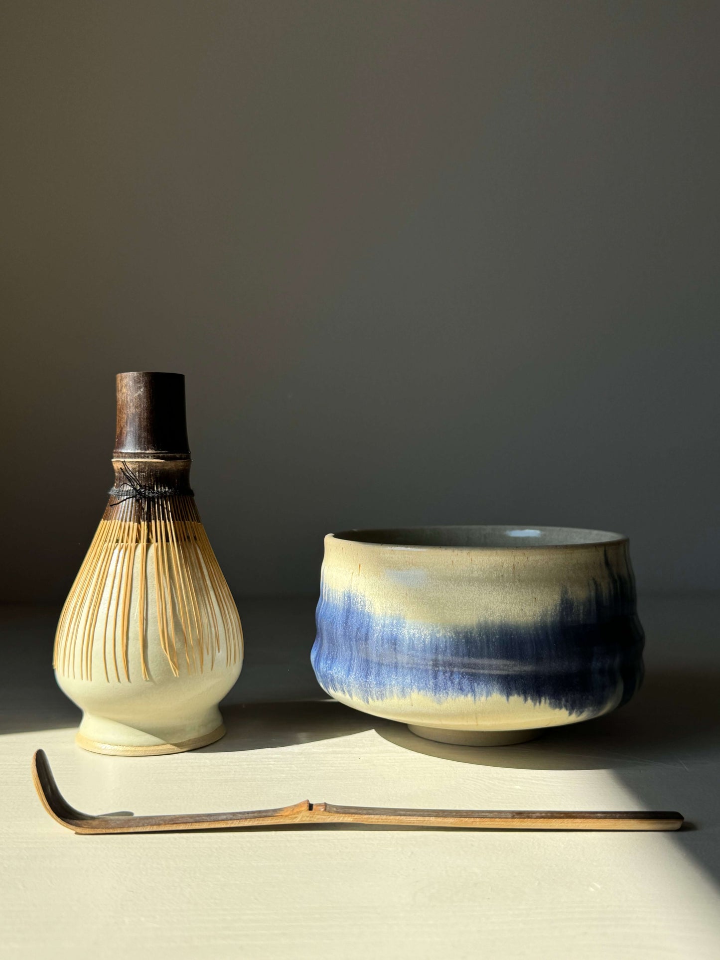 Cobalt blue matcha bowl with moonstone glaze, accompanied by a traditional bamboo matcha whisk and scoop.