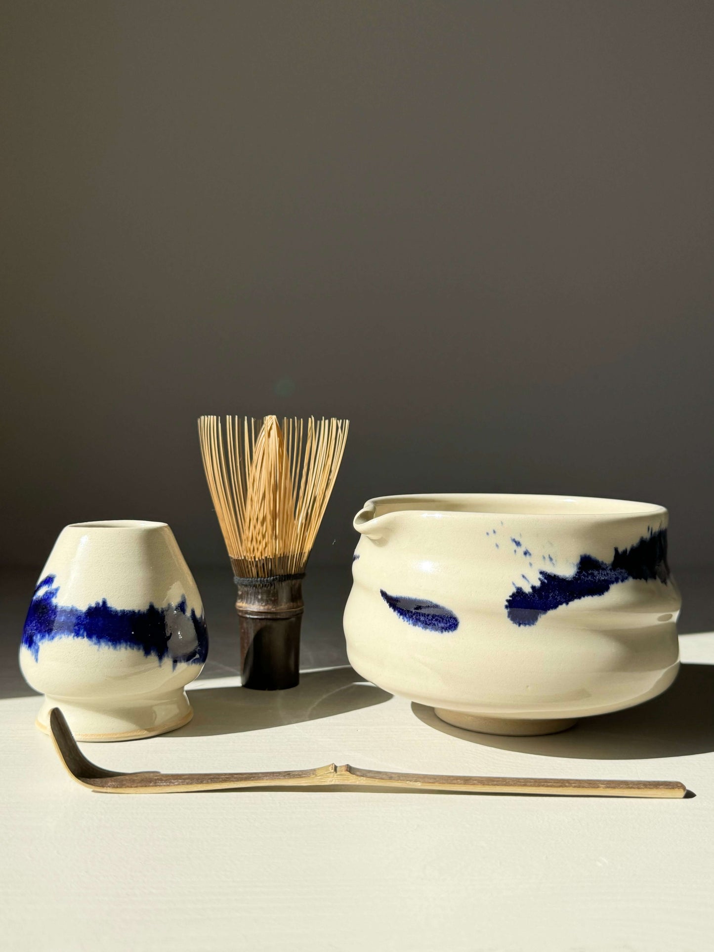 Handmade Gosu Series Matcha bowl with spout, cobalt blue accents, and matcha whisk, perfect for tea preparation.