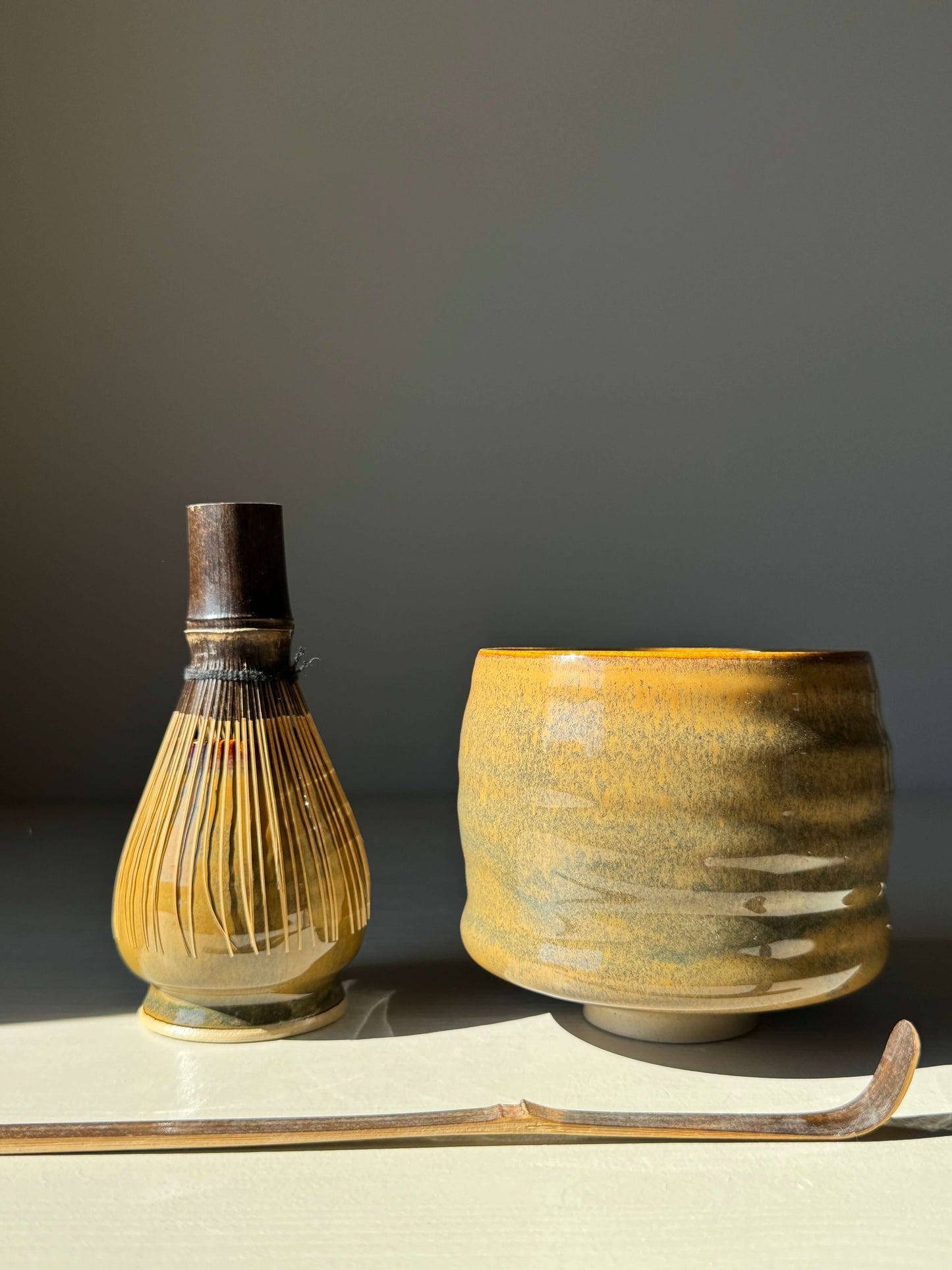 Matcha whisk holder with bamboo whisk and Tenmoku glaze, featuring rich earthy tones, perfect for maintaining whisk shape and enhancing tea setup.