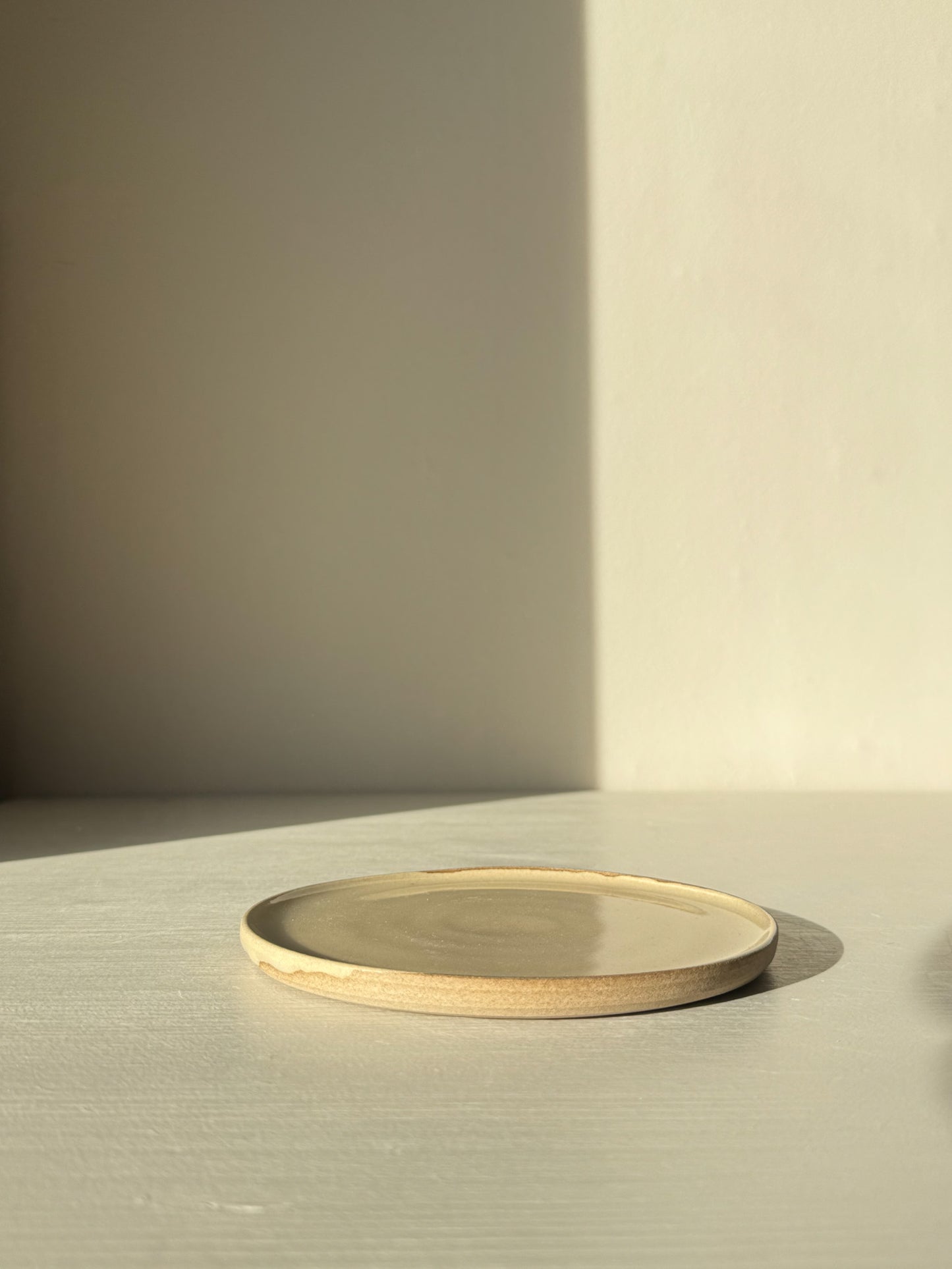 Minimalist ceramic plate with beige and cream tones on a light surface