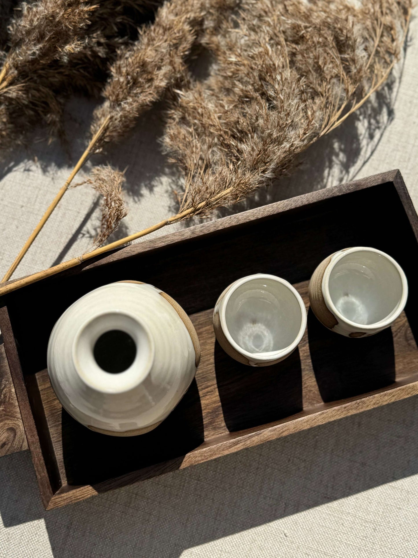 Yuki Series sake set with toffee clay and white glaze on a wooden tray, featuring a bottle and two cups, perfect for everyday use.