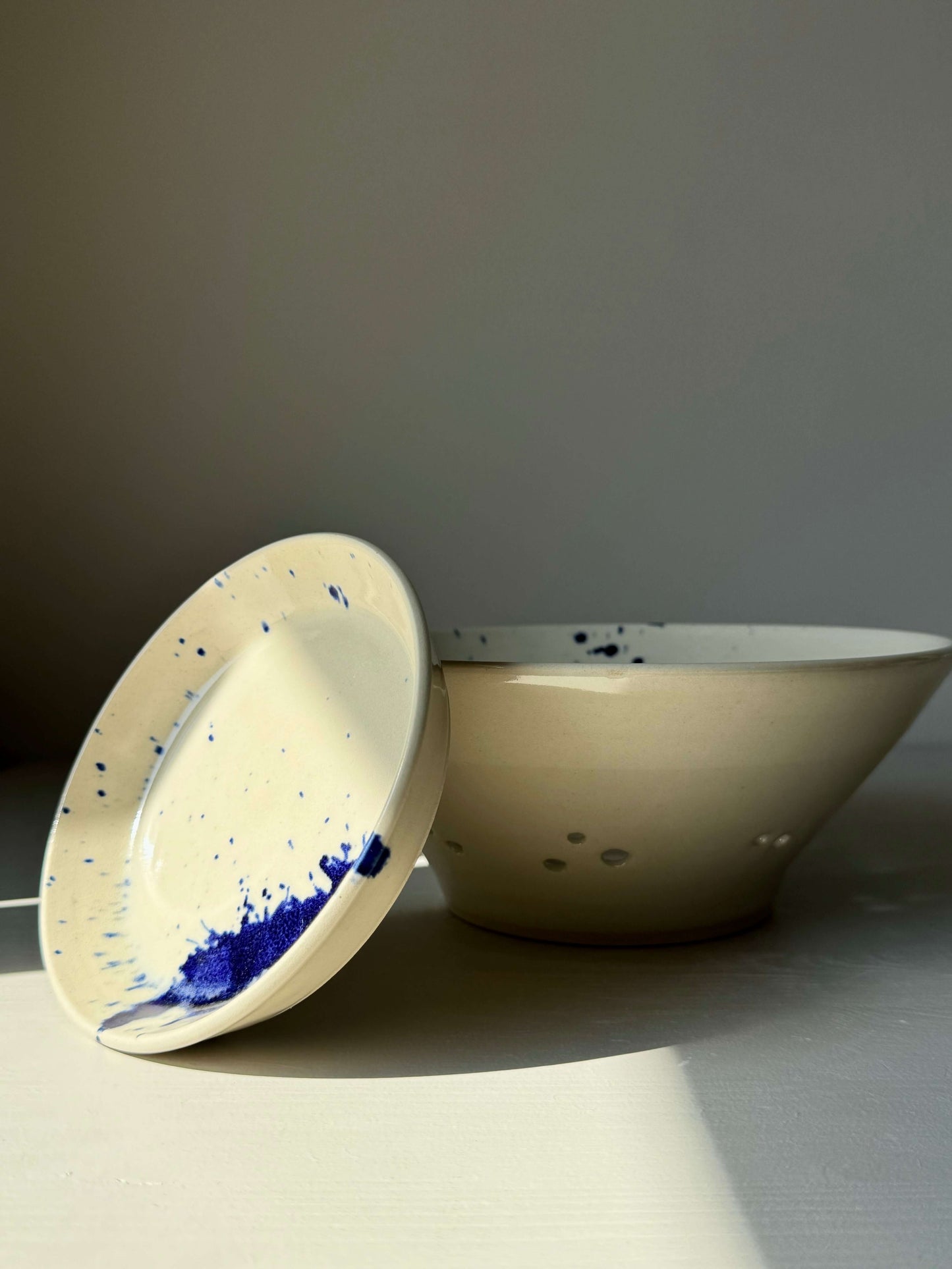Sculptural berry bowl with cobalt blue splashes from Gosu Series, designed for rinsing and serving fresh fruit. Includes matching drip plate.