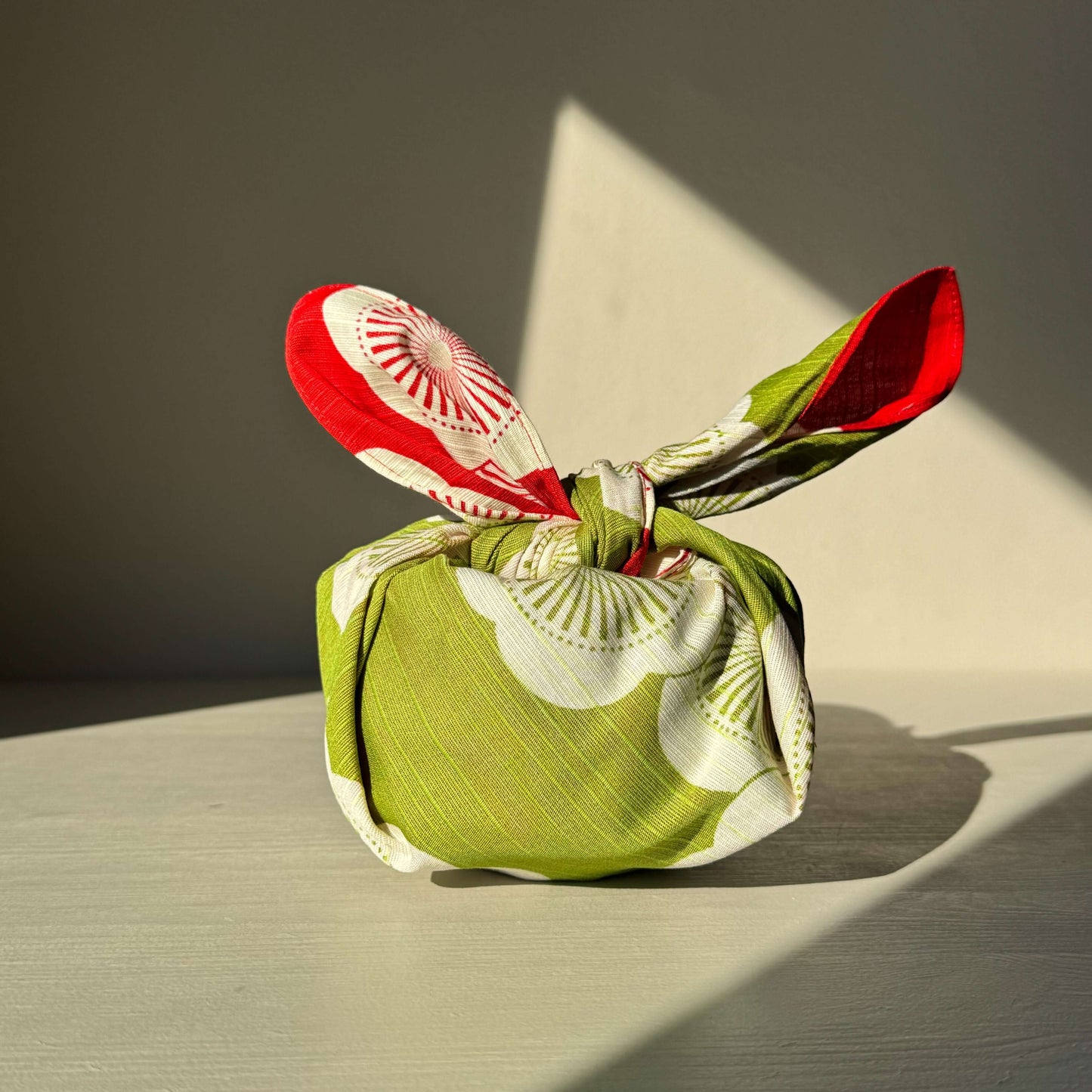 Small Furoshiki in red and green, featuring plum blossom design, symbolizing happiness and resilience, perfect for gift wrapping.