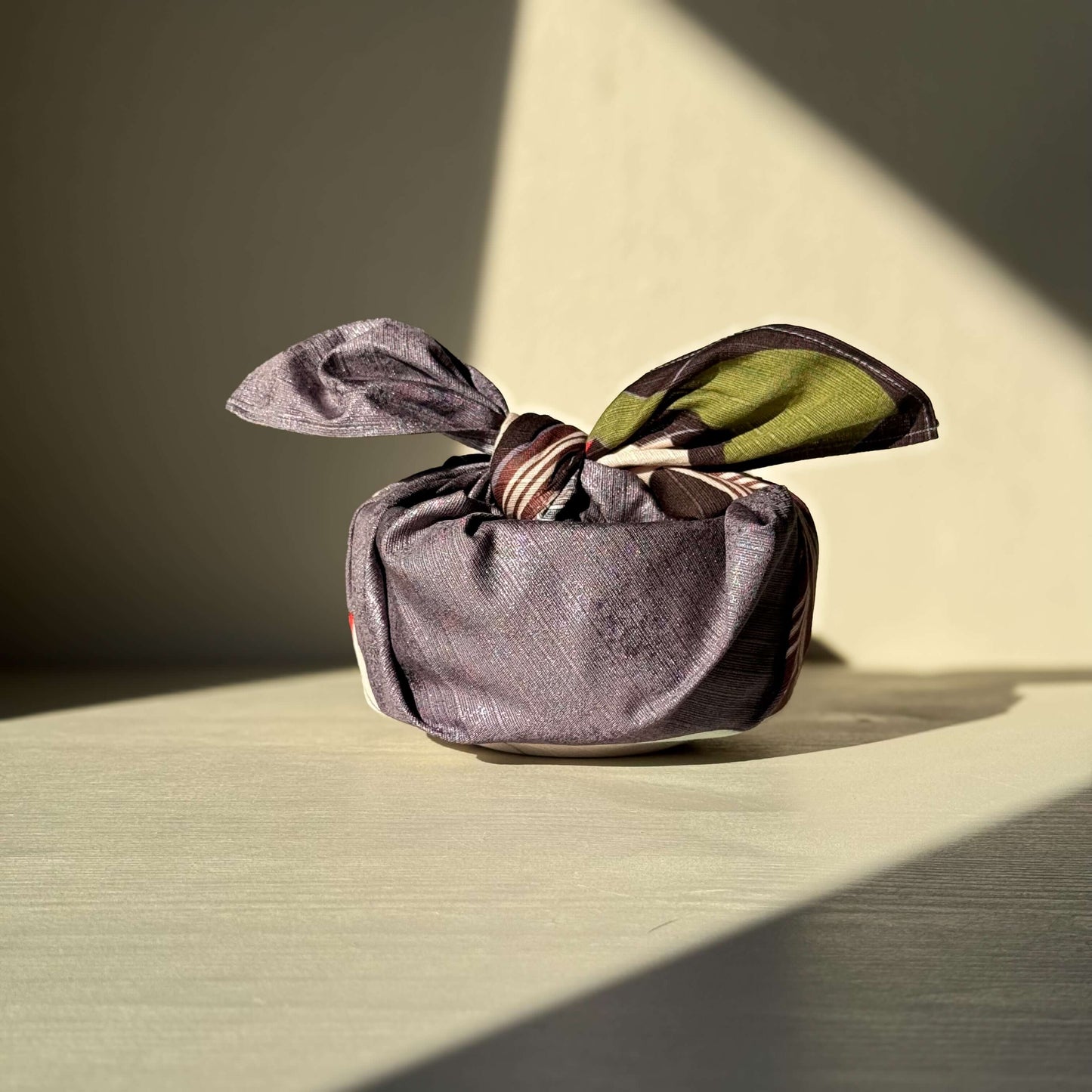 Small Furoshiki - Sharaku Gray wrapping a handmade ceramic, showcasing a reusable and eco-friendly gift wrap option.