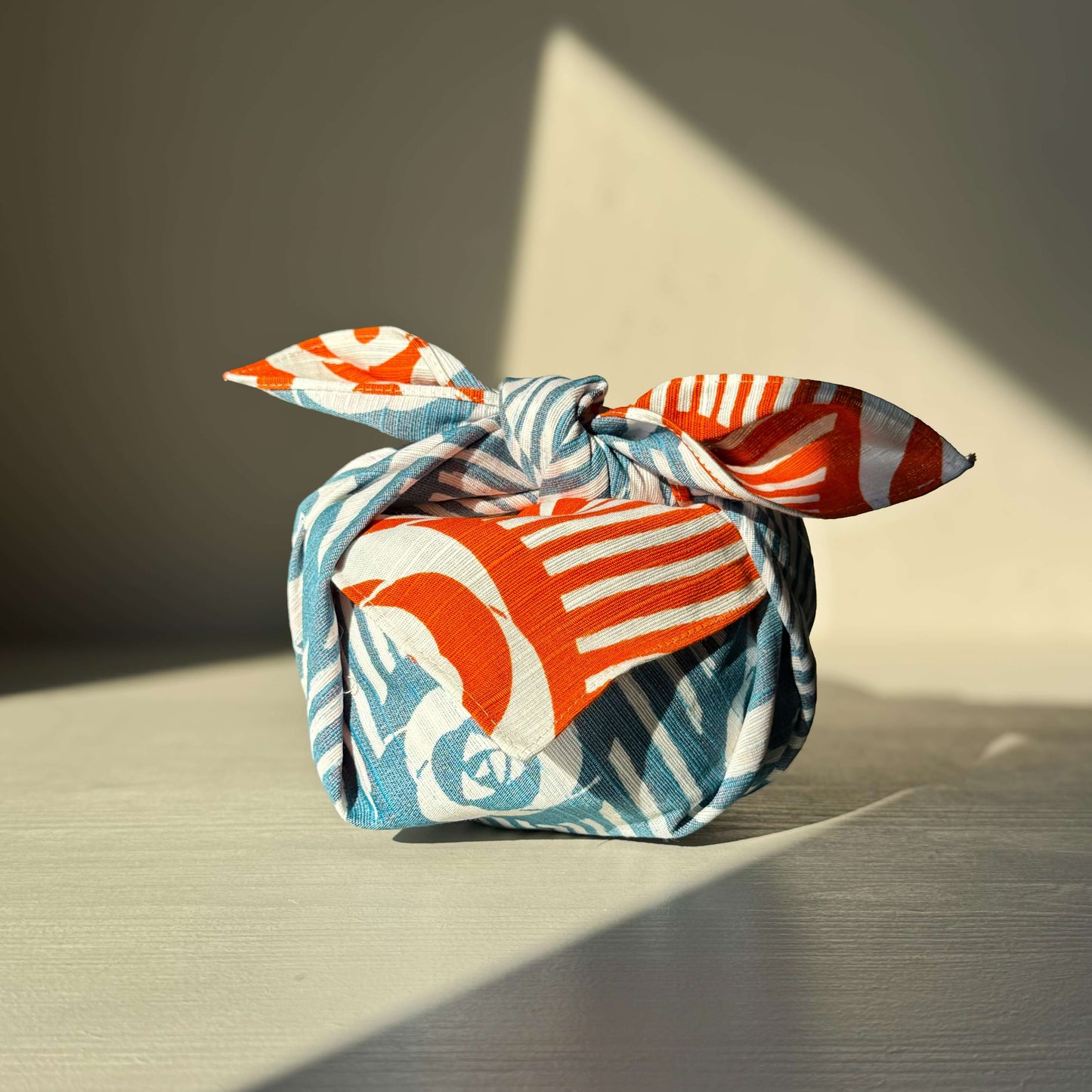 Colorful Small Furoshiki wrapped package with classic Camellia Orange and Blue floral pattern, symbolizing elegance and Japanese tradition.