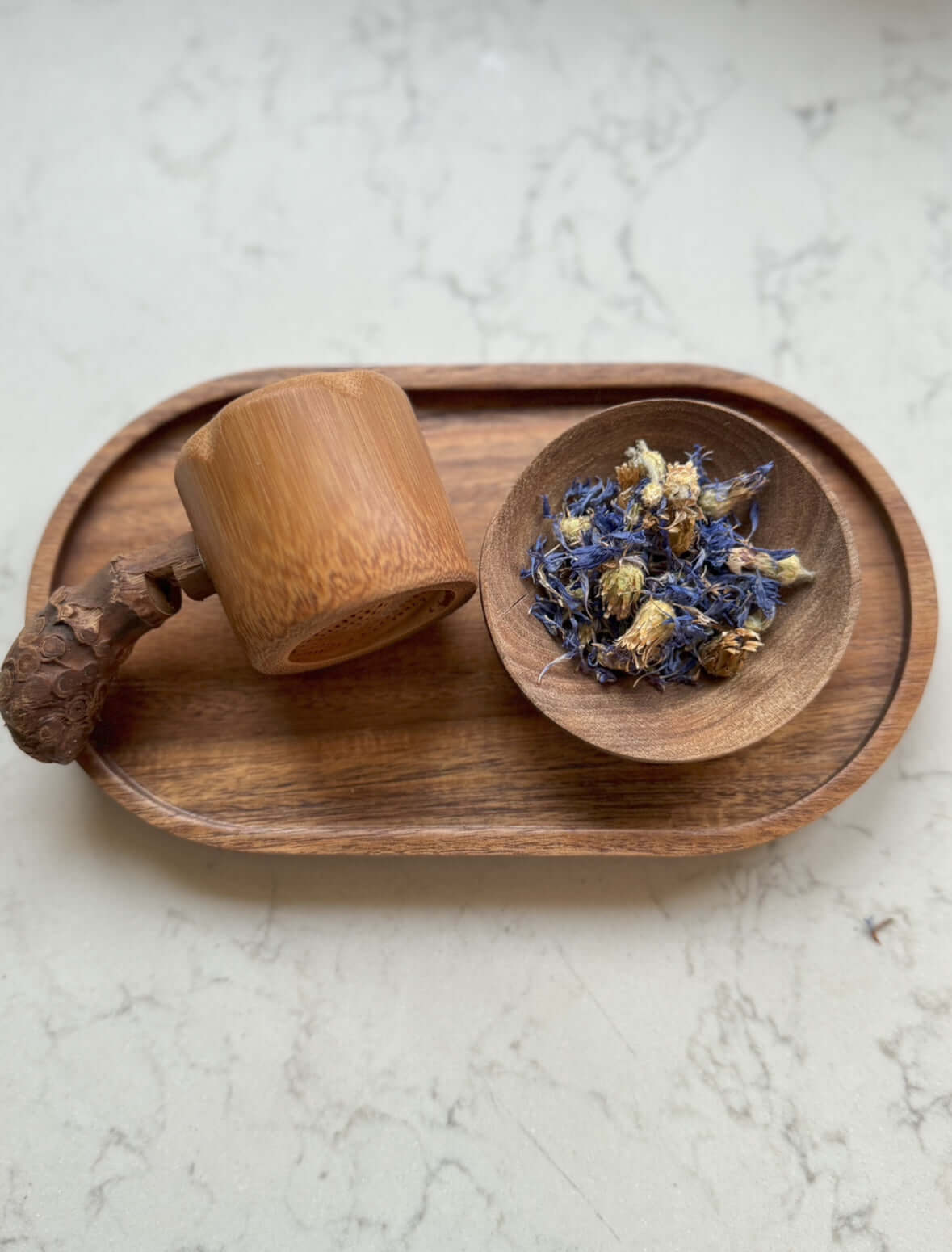 Hand-carved walnut wood bowl and cup on a tray with dried flowers; unique Marrakech craftsmanship.