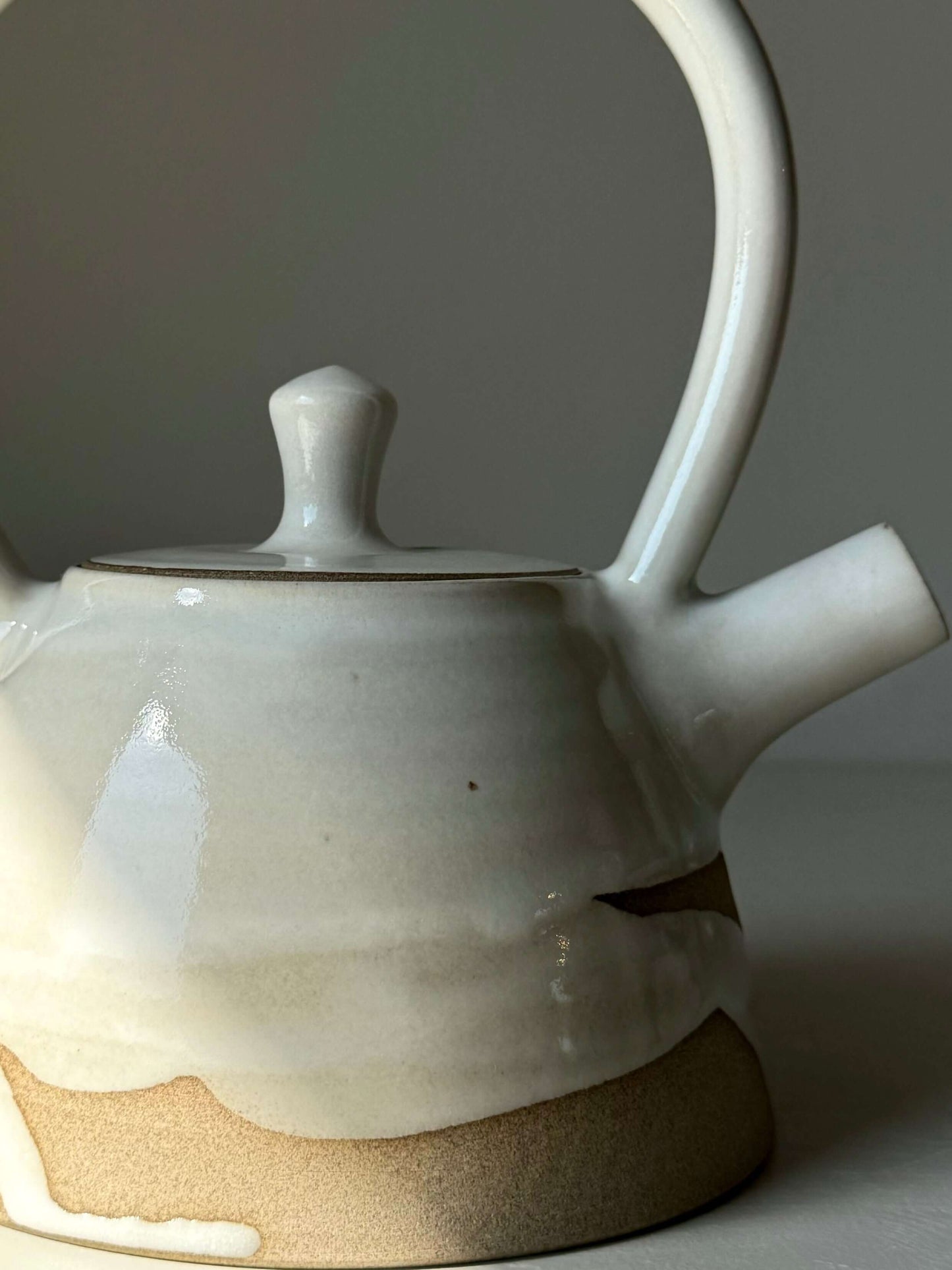 Yuki Series #03 teapot with sculptural handle, white glaze, unglazed clay base. Ideal for a calming, balanced tea experience.