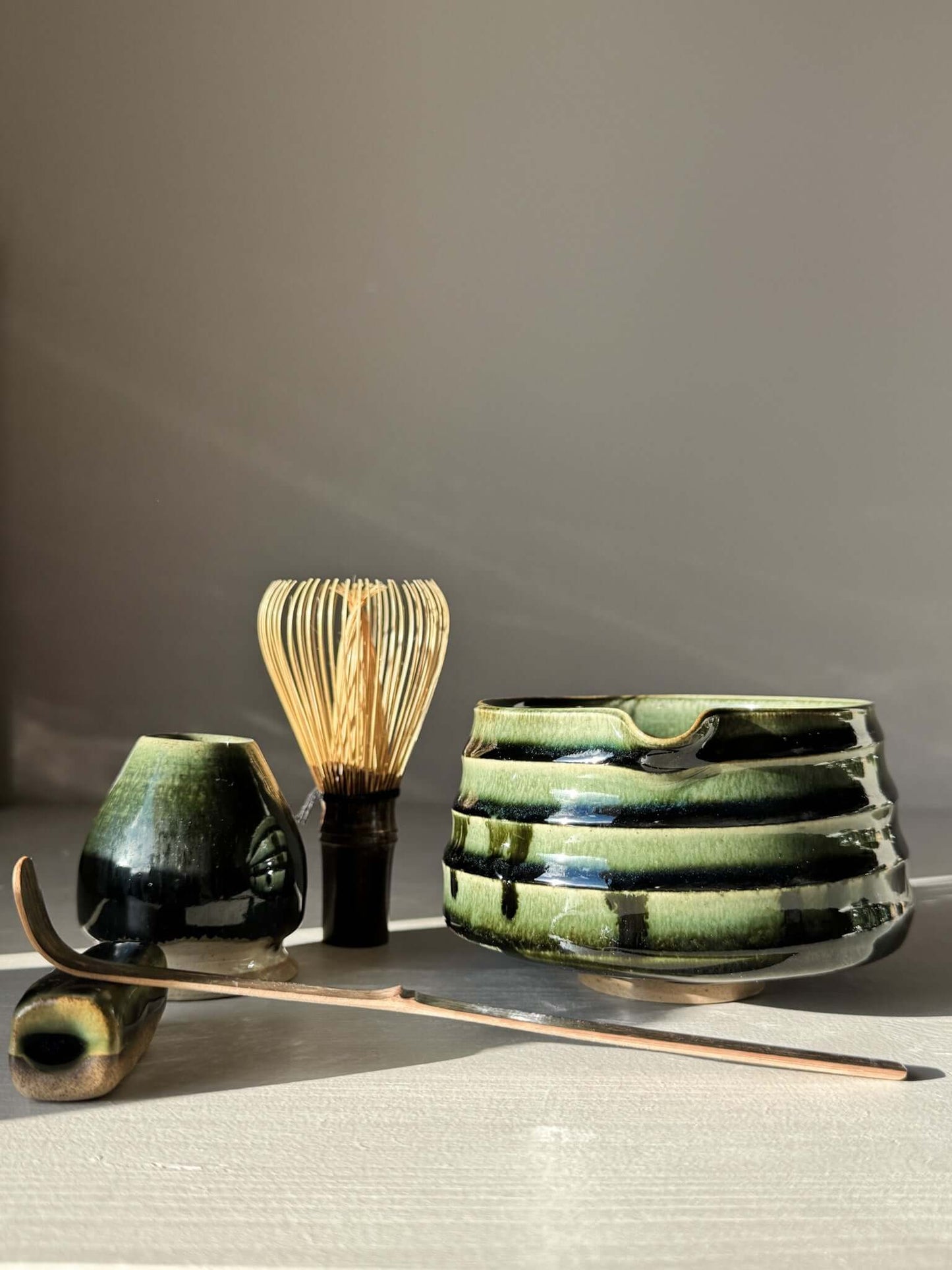 Textured Matcha Bowl Spout - Hinoki #01 with green glaze and spout, paired with whisk, scoop, and cup on a light surface