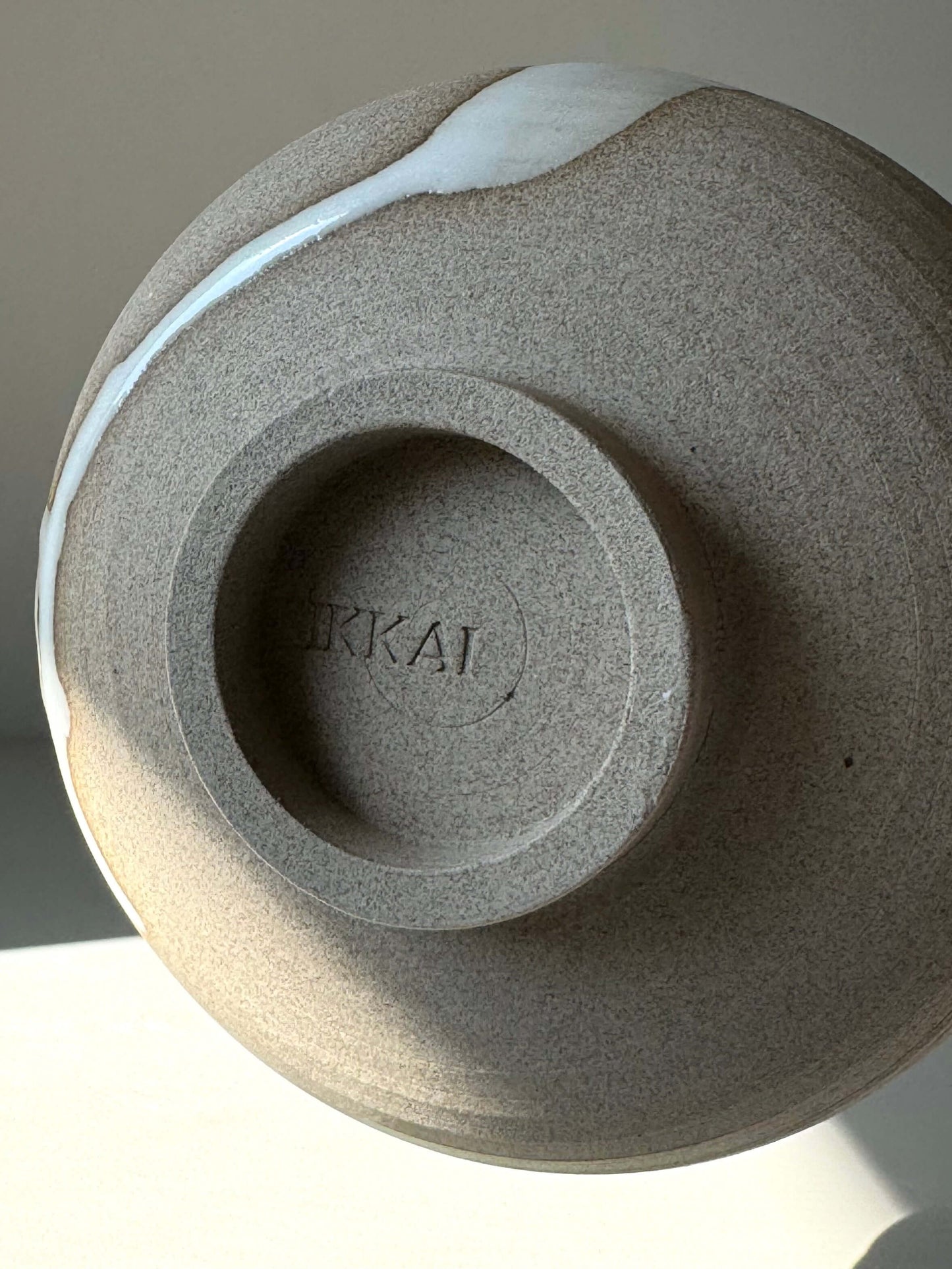 Underside of handmade Matcha bowl from Yuki Series, showing toffee clay and unique glaze drip pattern.