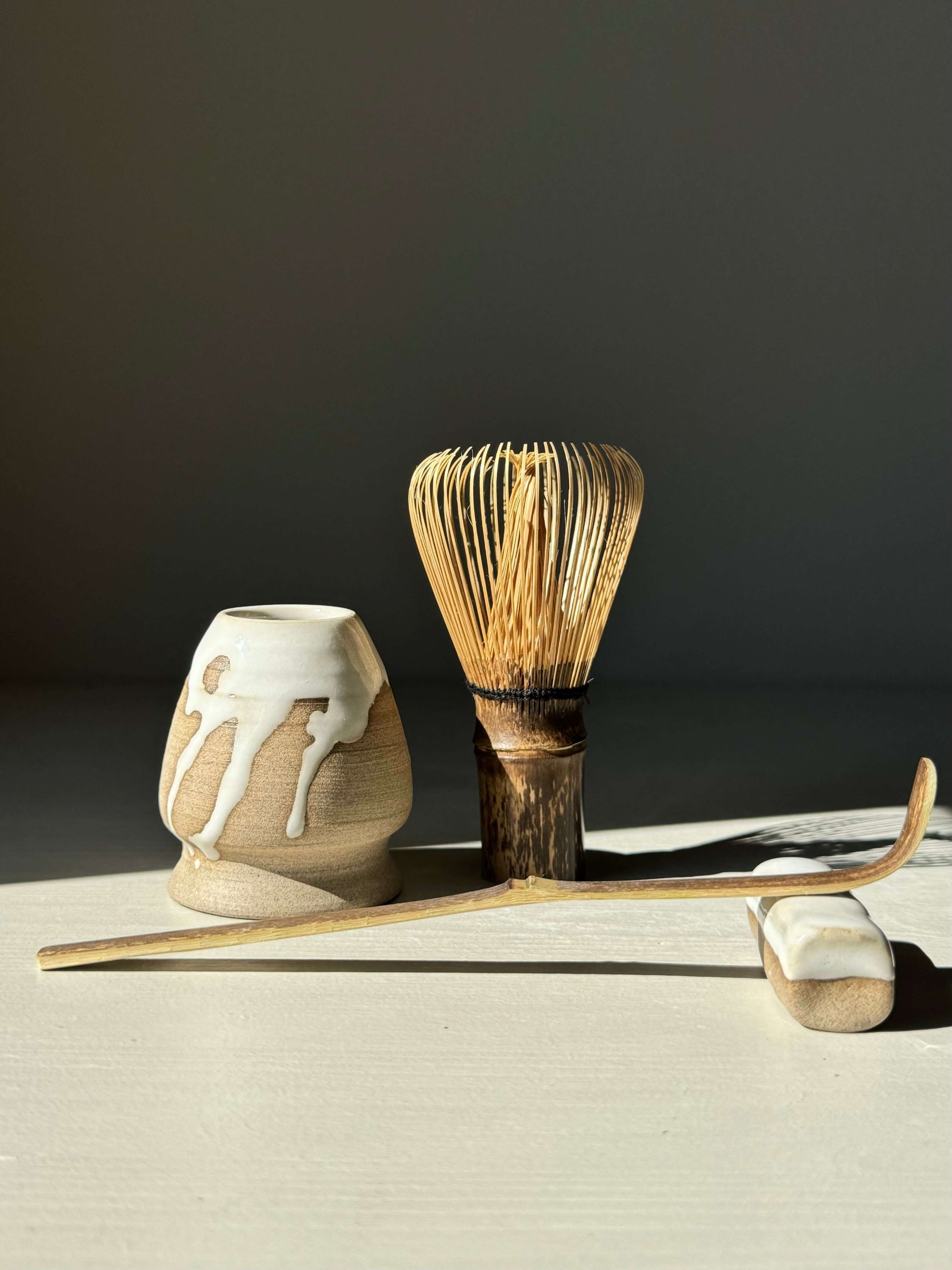Handmade ceramic Chopstick & Matcha Spoon Rest – Yuki Series with white glaze and toffee clay, shown with a bamboo whisk and holder.